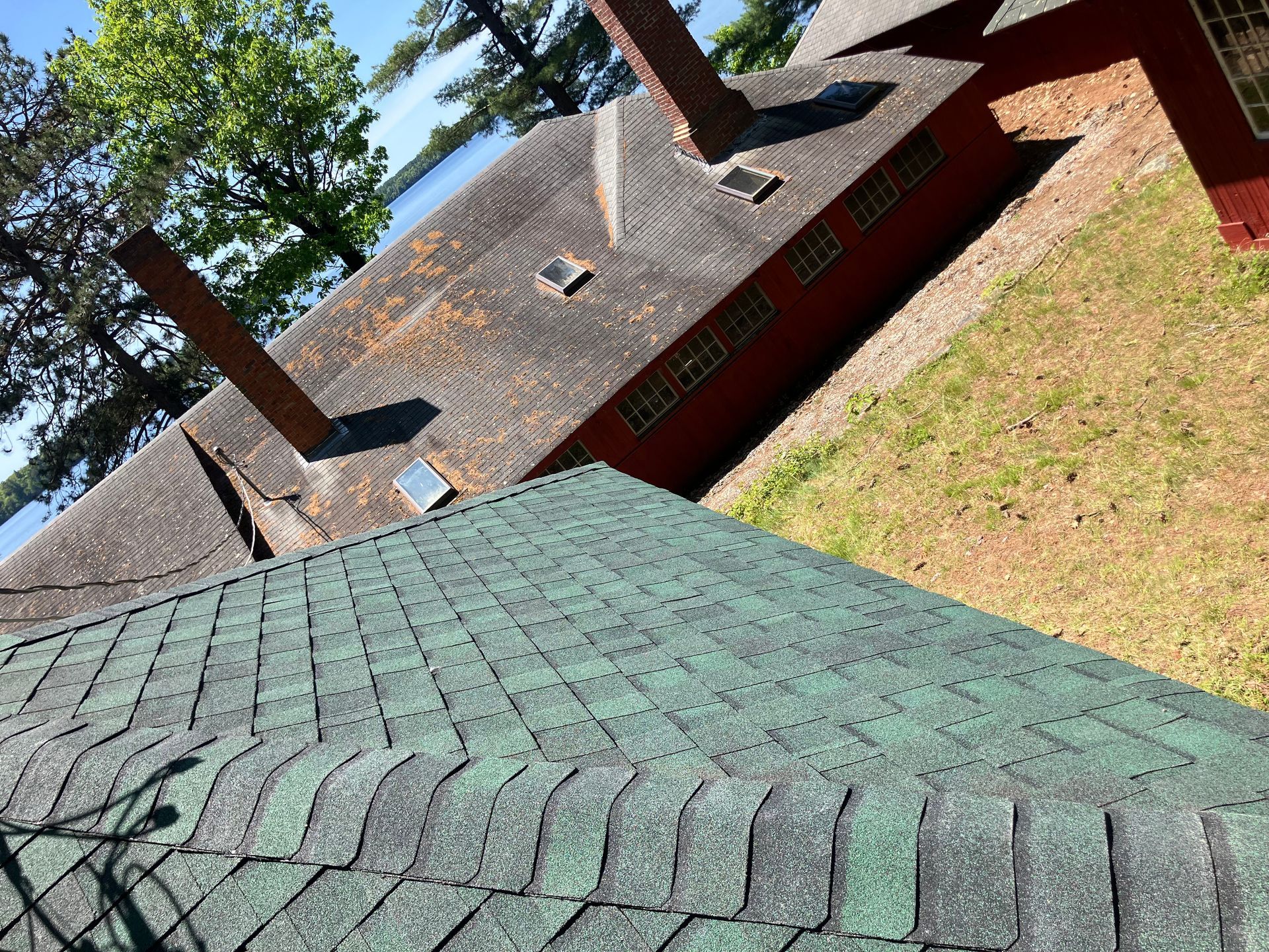 A green roof with a red building in the background