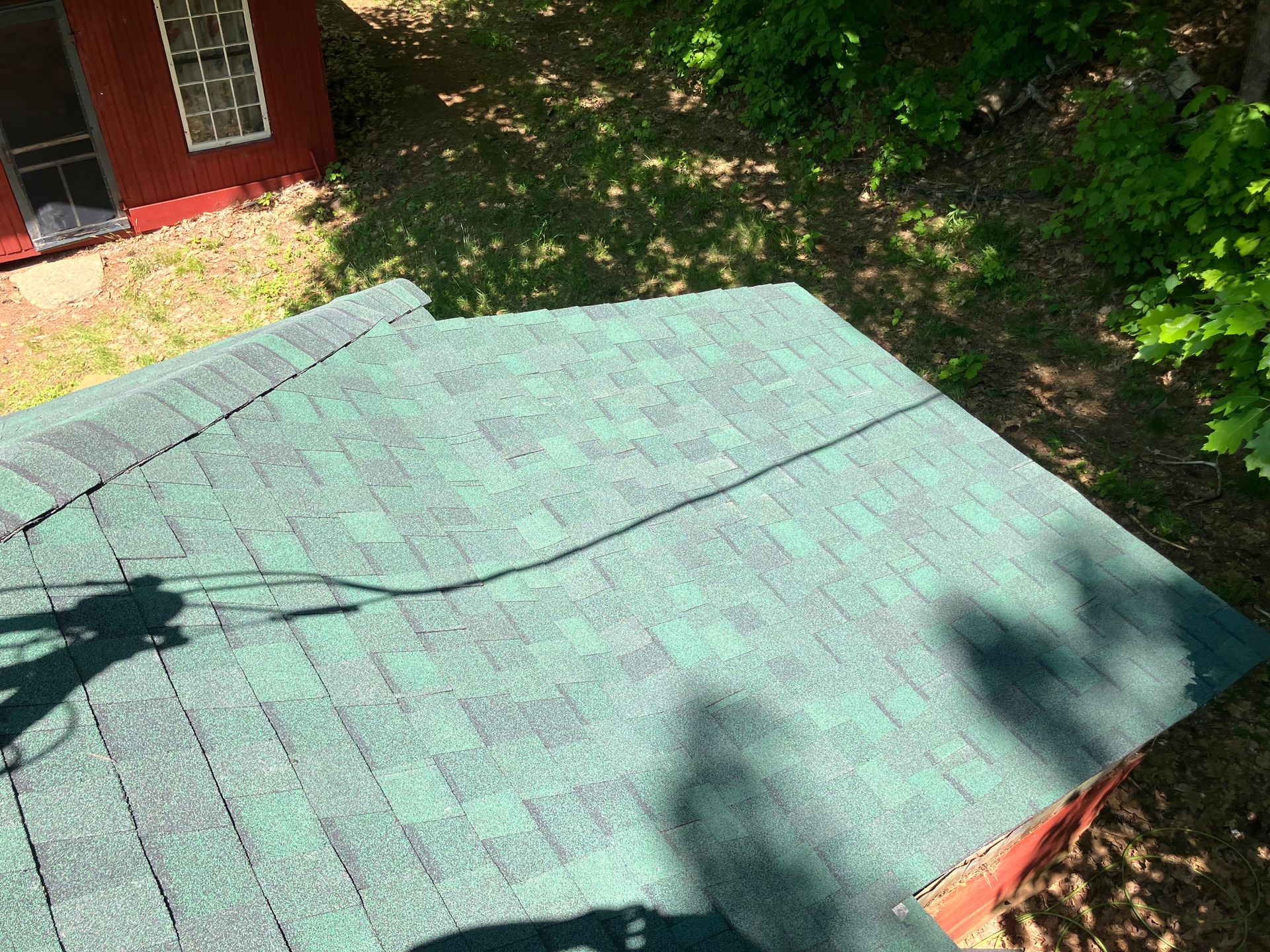 An aerial view of a green roof with a red shed in the background.