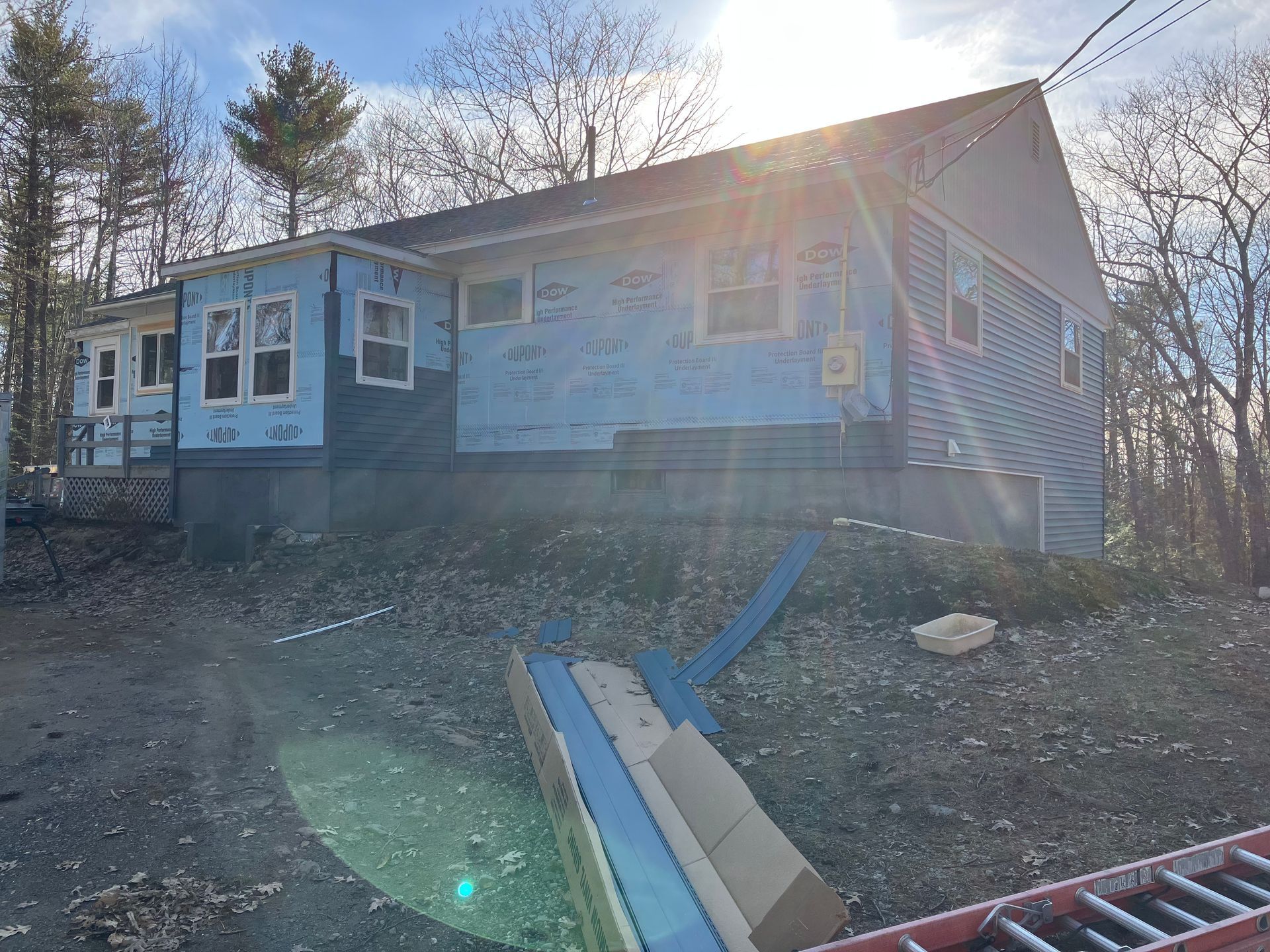 A house under construction with a ladder in front of it.