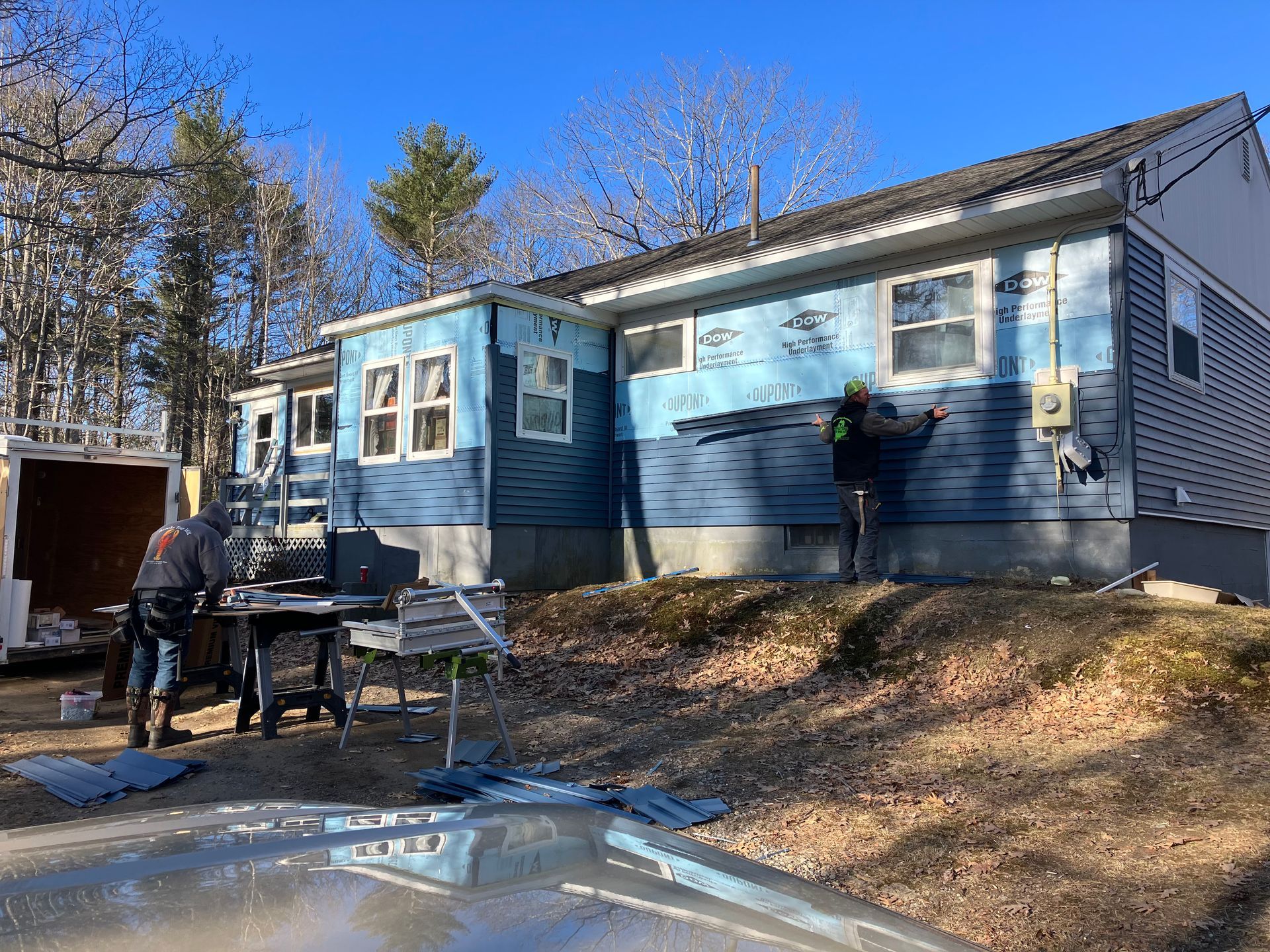 A group of people are working on the side of a house.