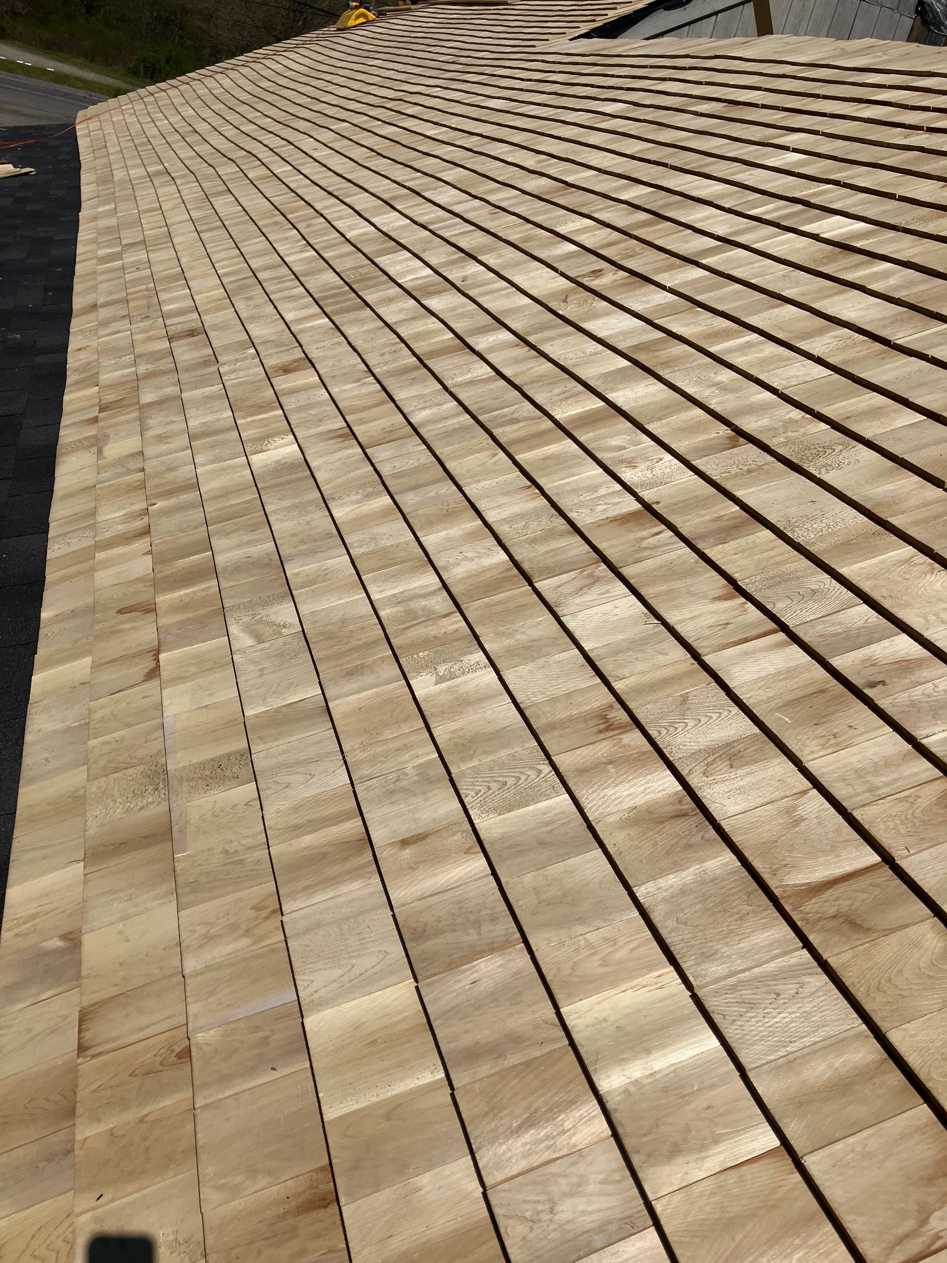 A close up of a wooden roof with shingles on it.
