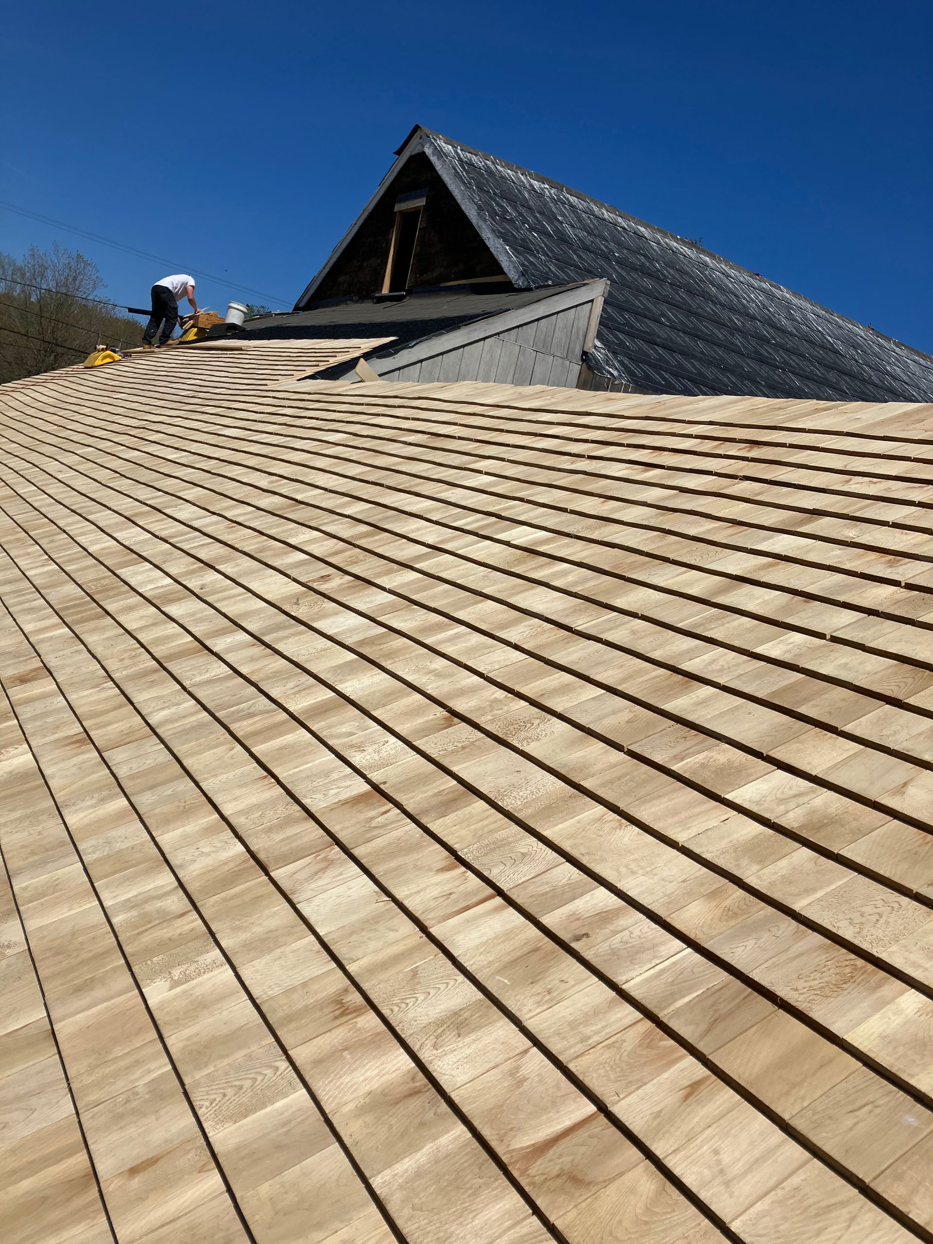 A close up of a wooden roof with a blue sky in the background.