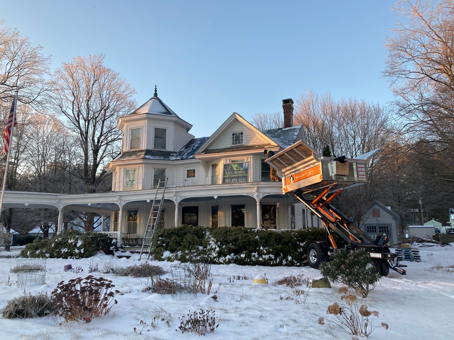 A large white house is covered in snow and a truck is parked in front of it