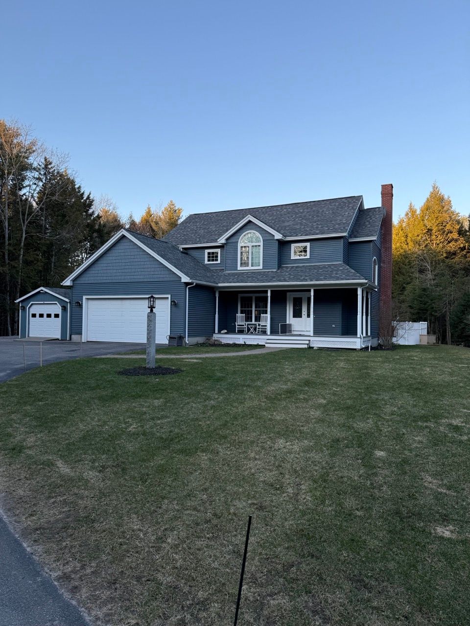 A large blue house with a porch and a garage