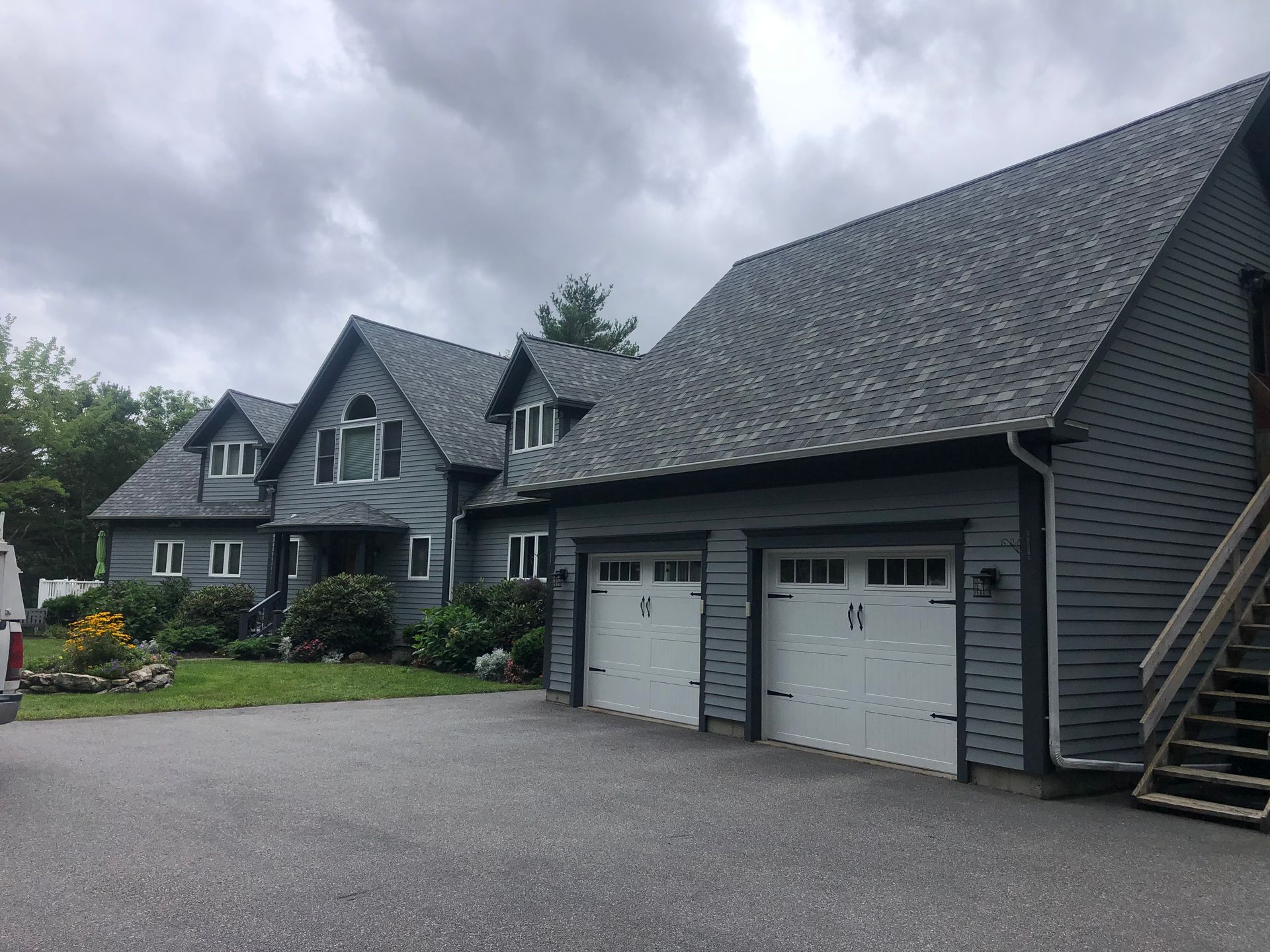 A large house with a garage and stairs in front of it
