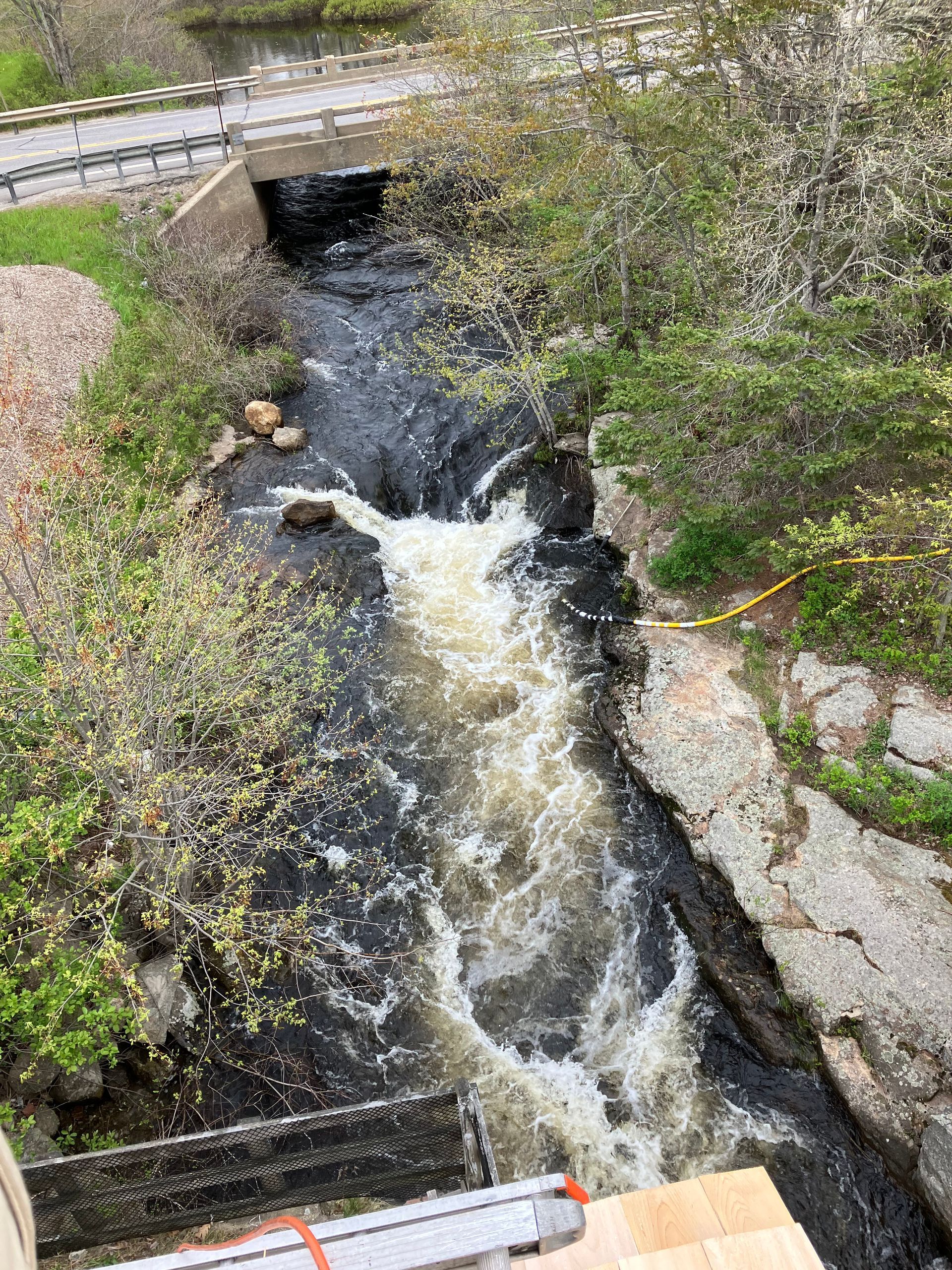 An aerial view of a river with a bridge in the background.