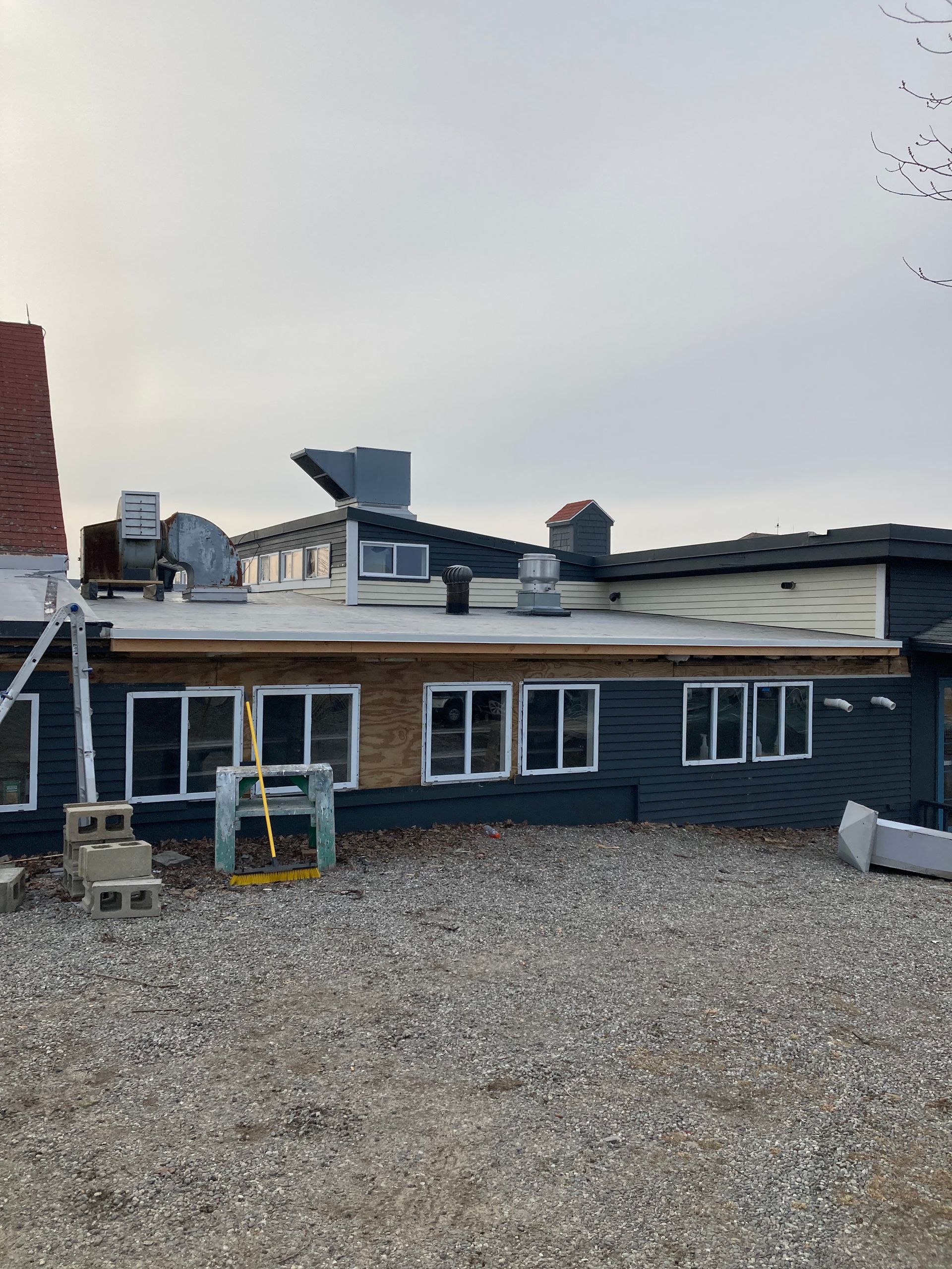 The back of a building with a lot of windows and a chimney.