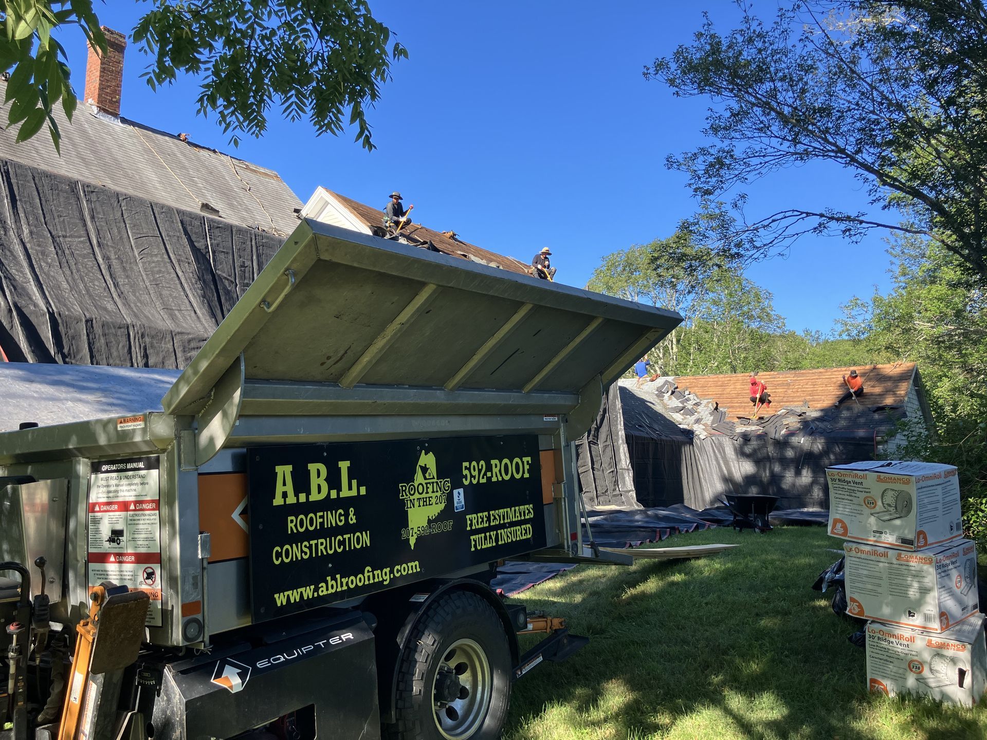 A dump truck that says a.b.l. is parked in front of a house