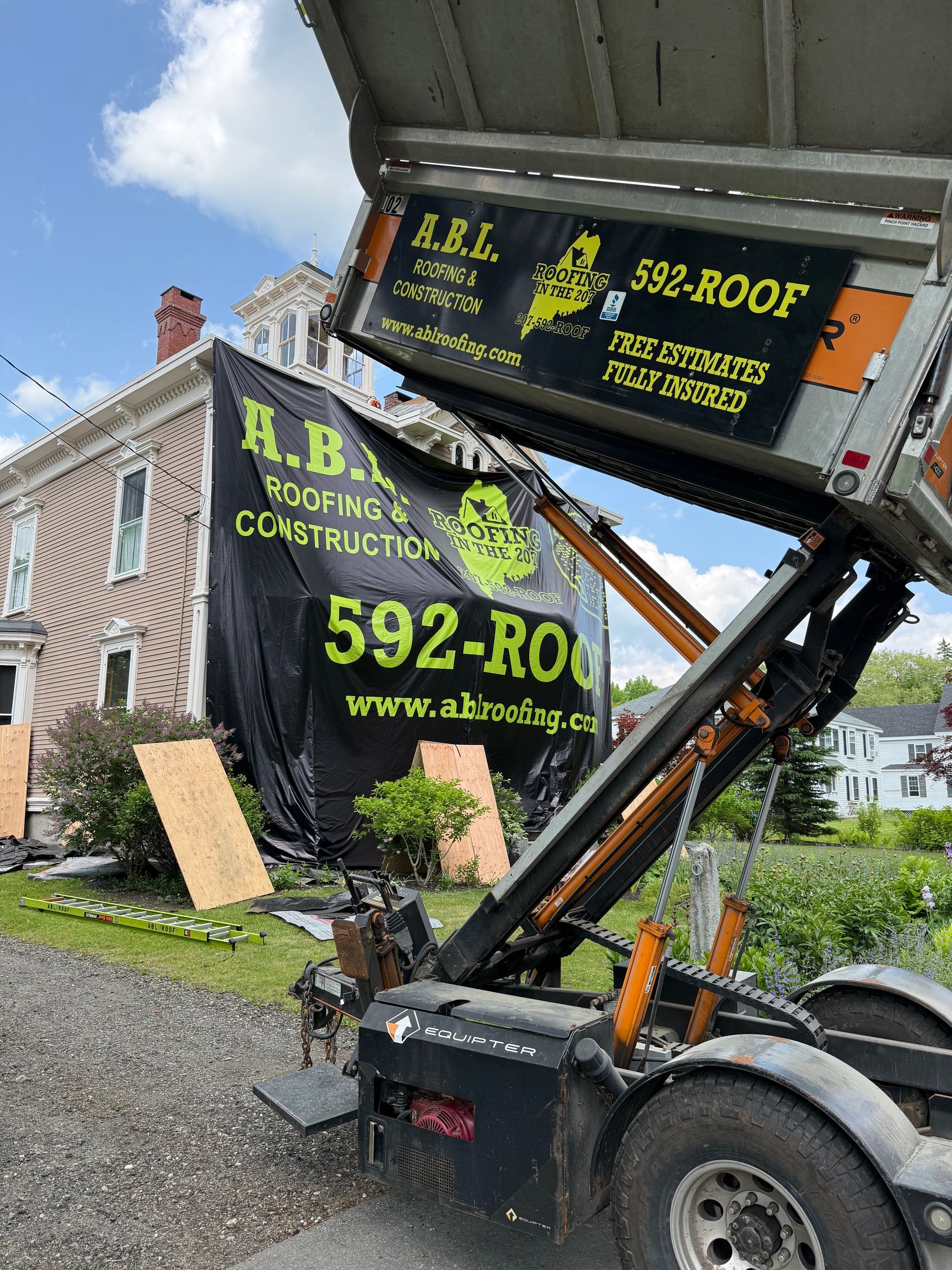 A dump truck is parked in front of a house.