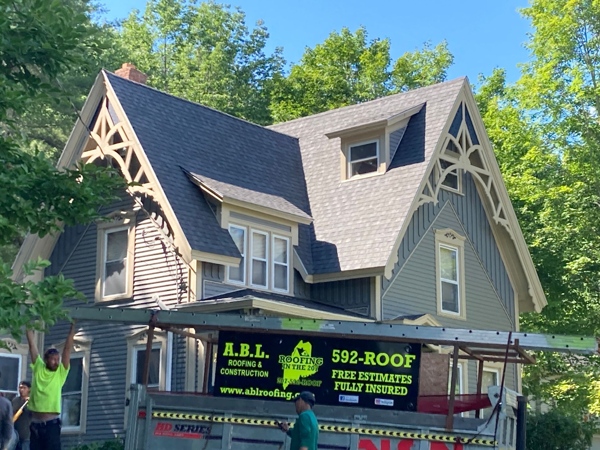 A man is standing in front of a house with a sign that says 502 roof