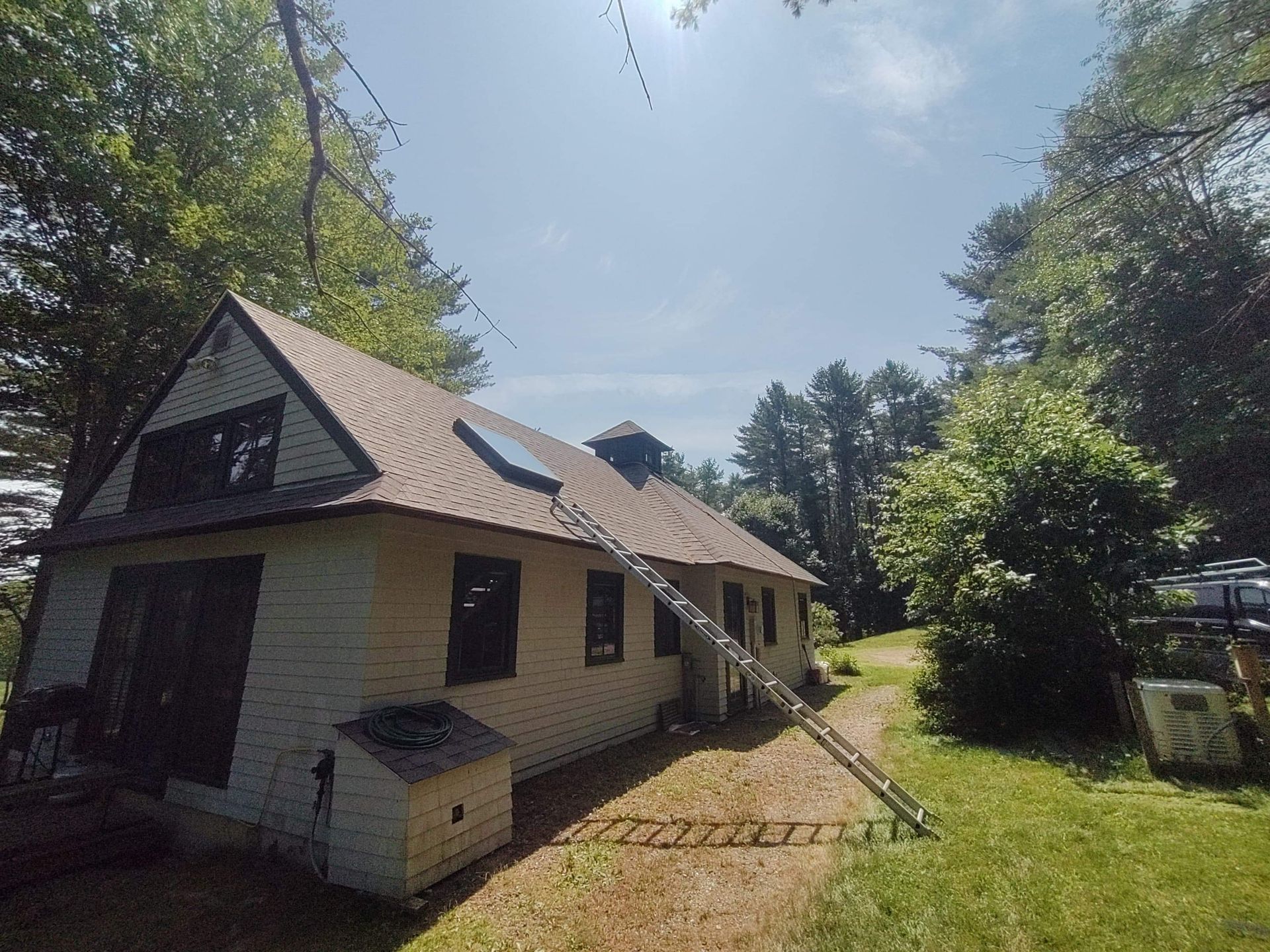 A white house with a ladder attached to the side of it.
