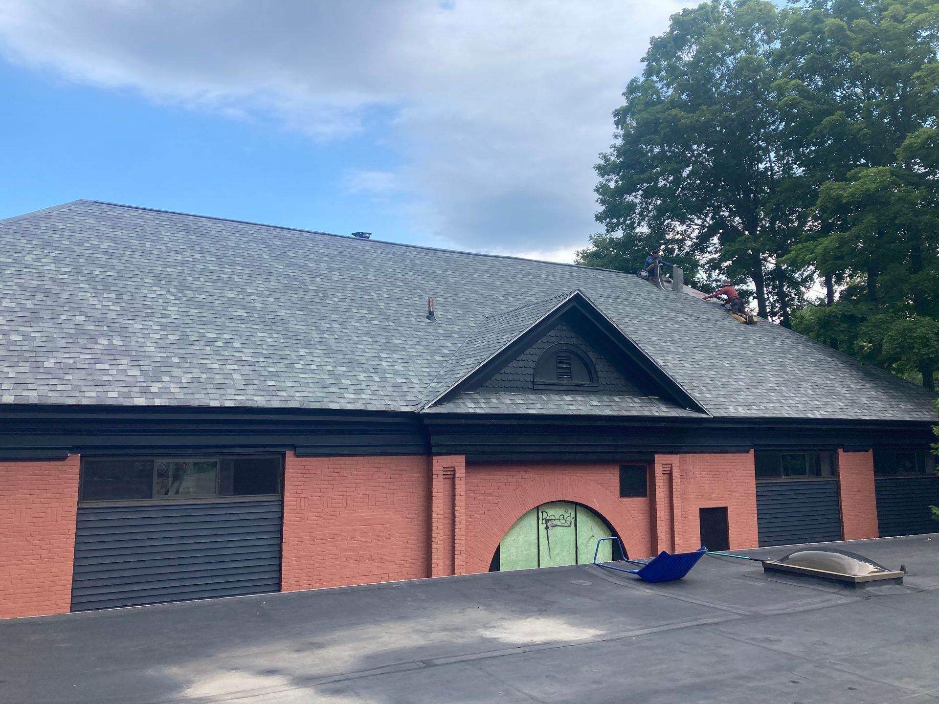 A house with a gray roof and a red garage door.