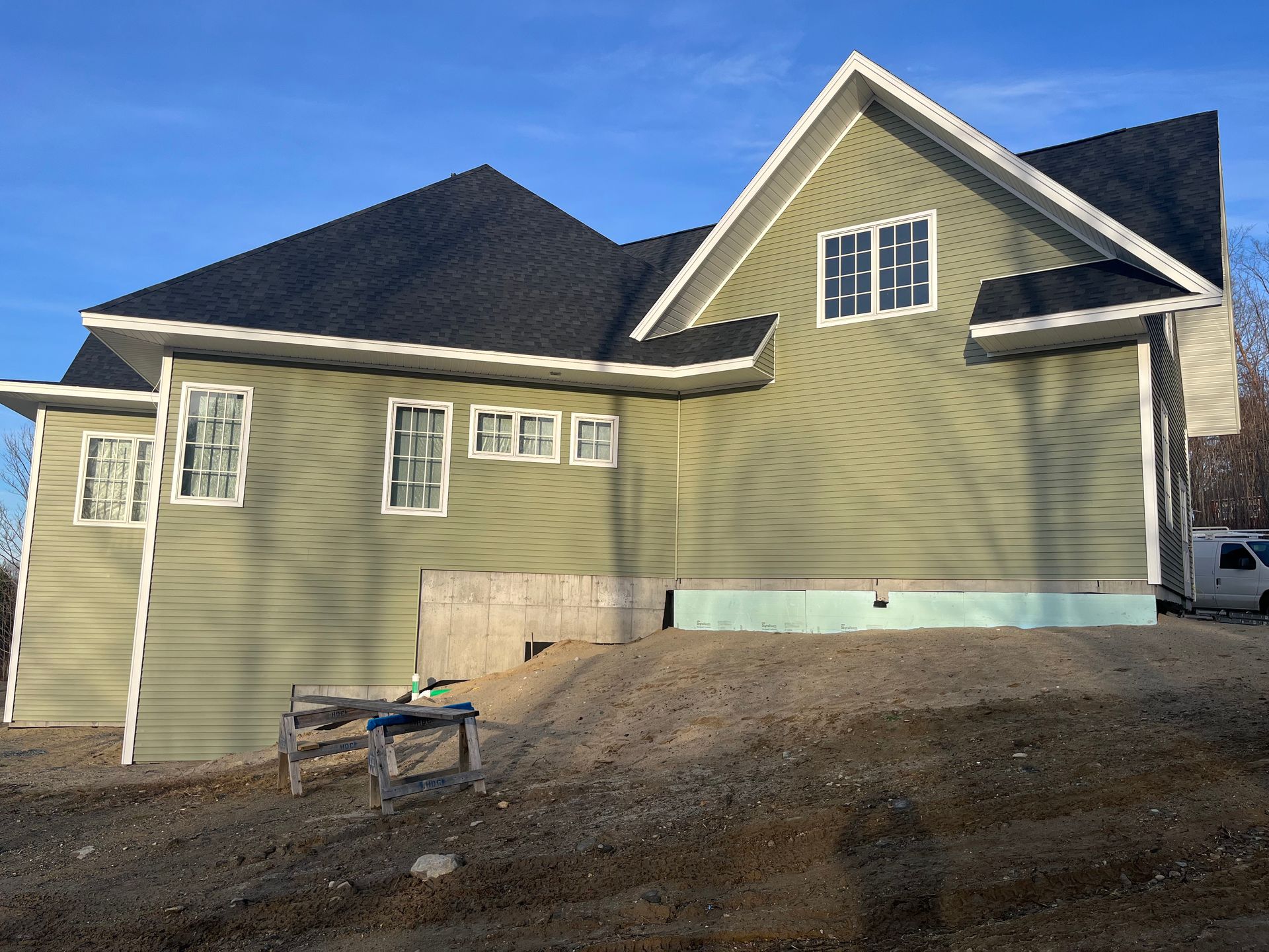 A green house with a black roof is under construction