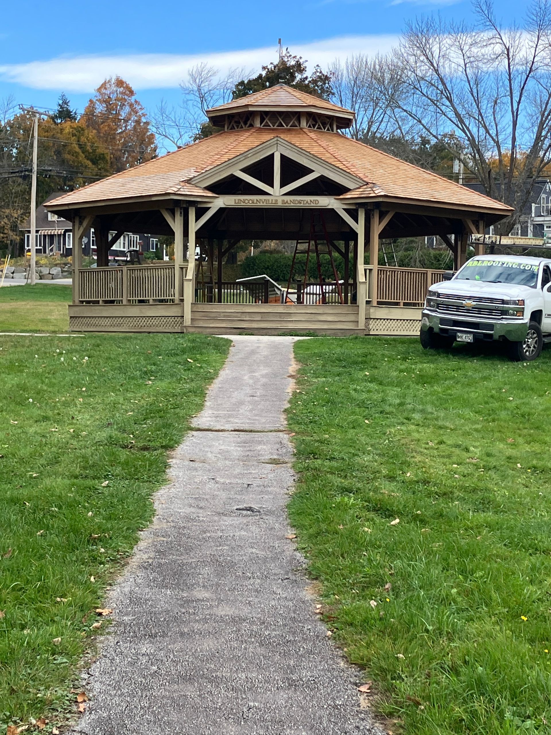 A gazebo in a park with a path leading to it.