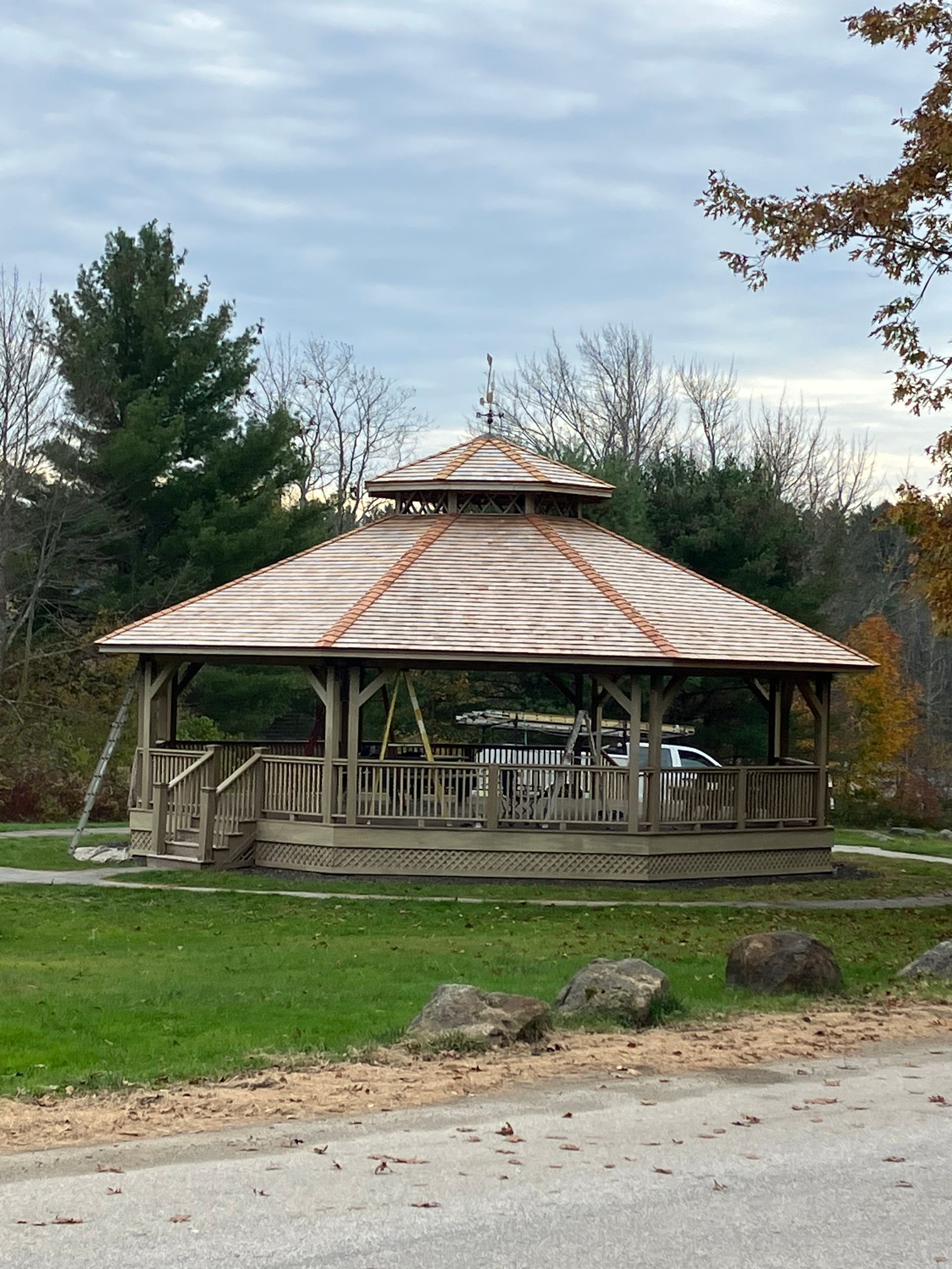 A gazebo is sitting in the middle of a grassy field.