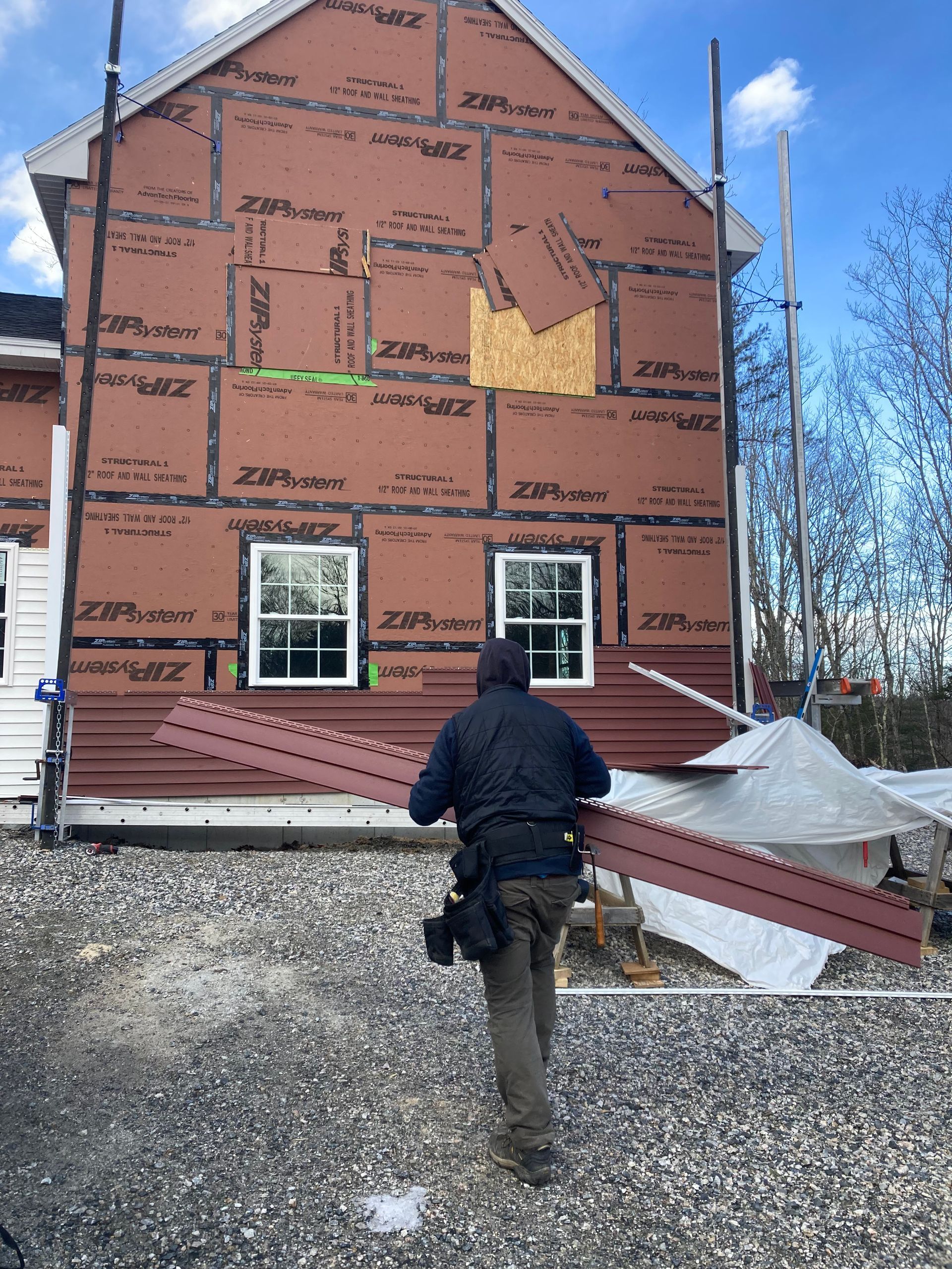 A man is standing in front of a house that is being built