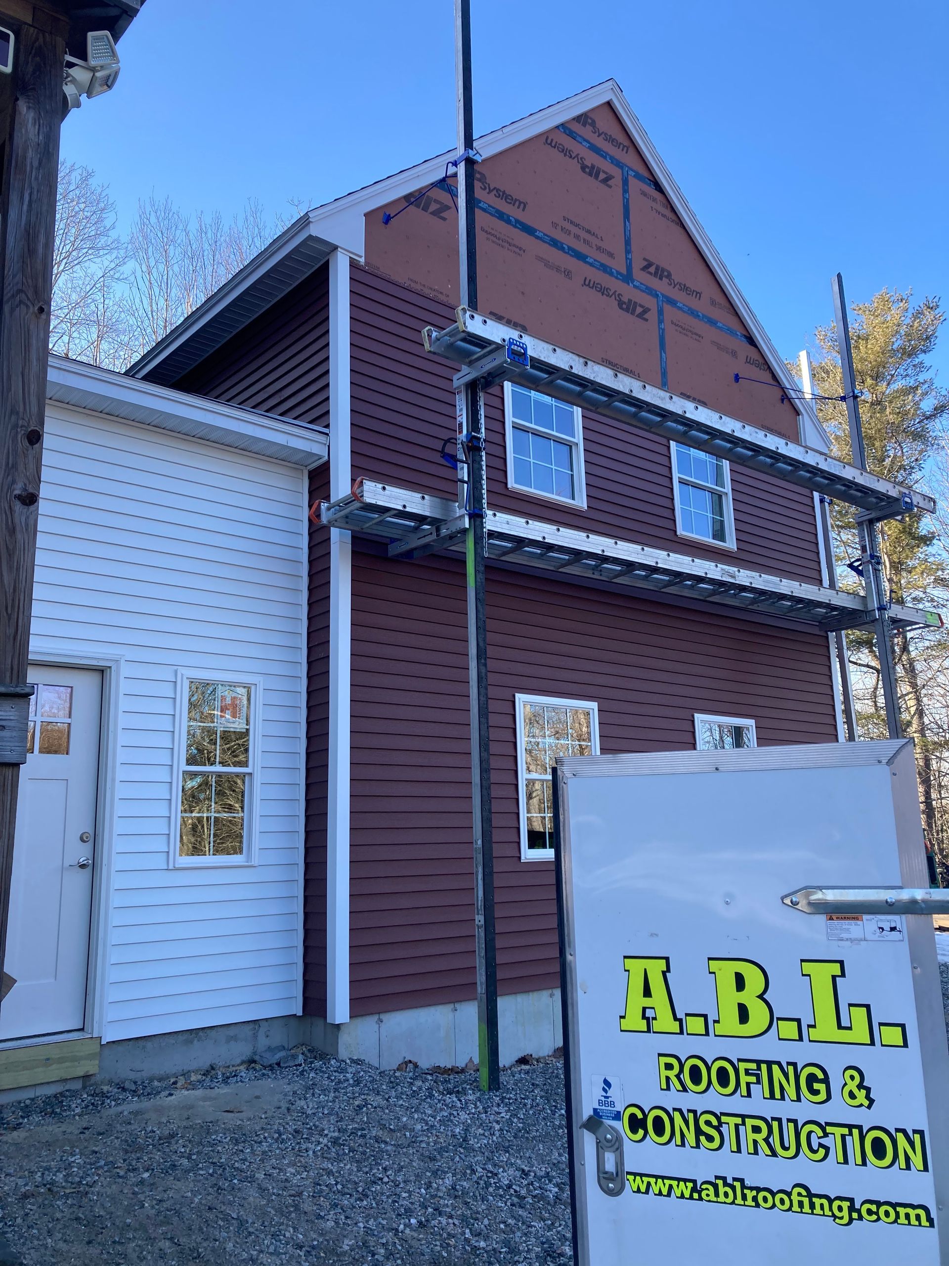 A building with a sign that says a.b.l. roofing & construction