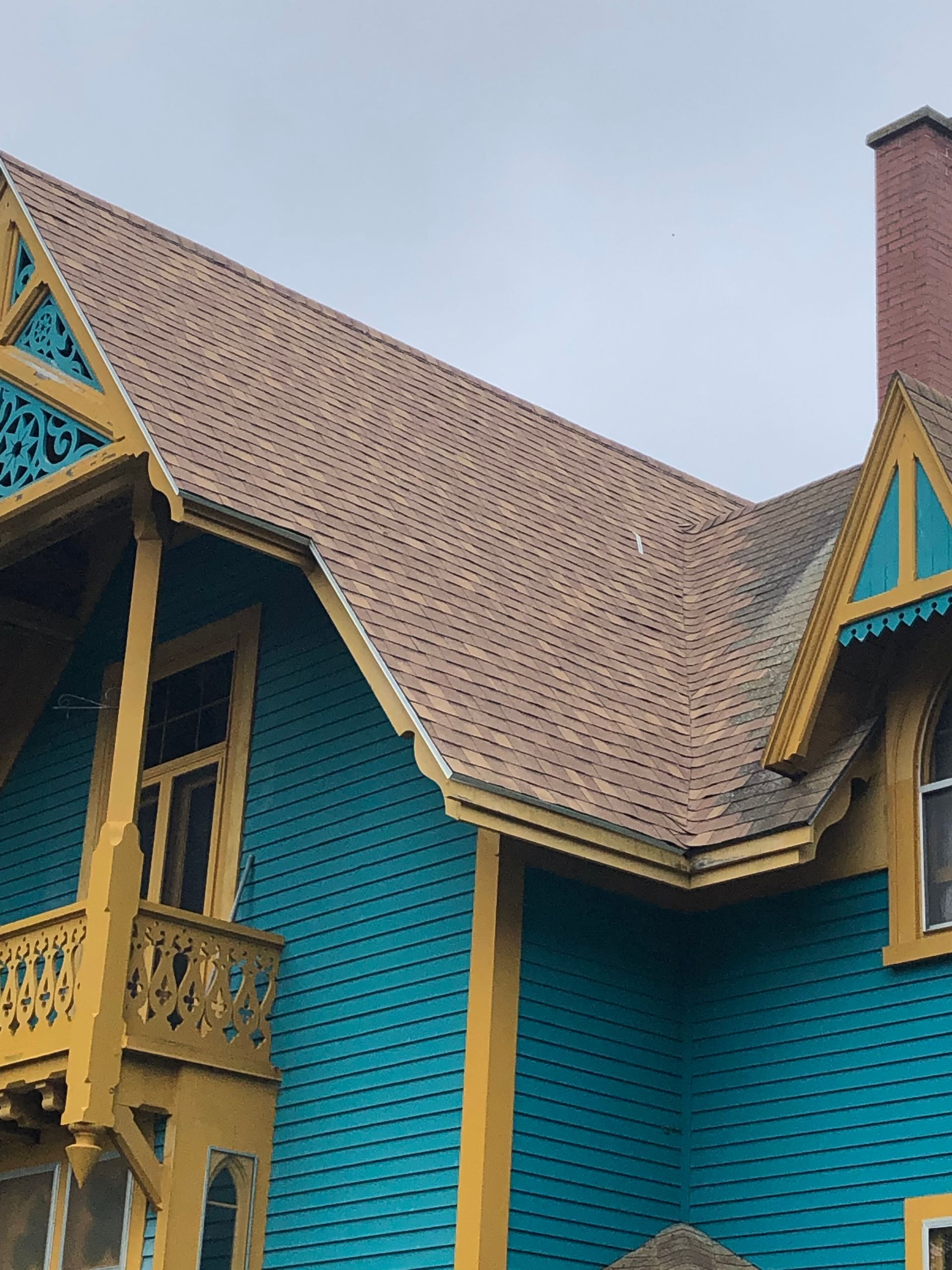 A blue and yellow house with a brown roof