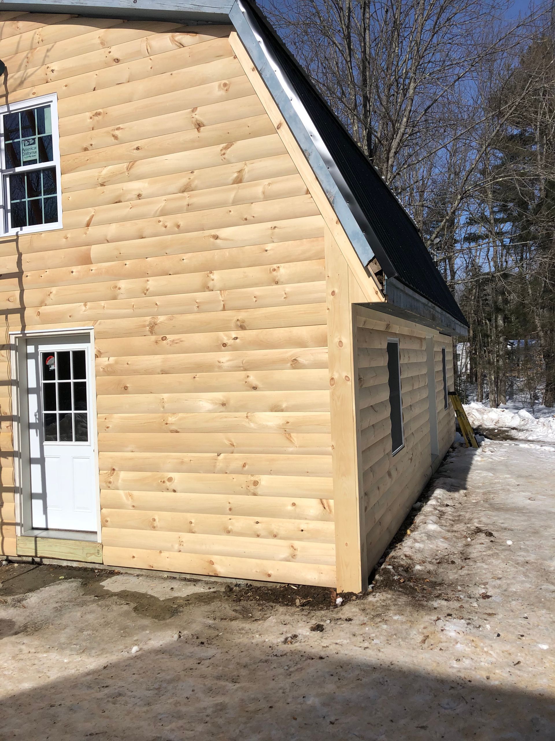 A house with a log siding and a white door