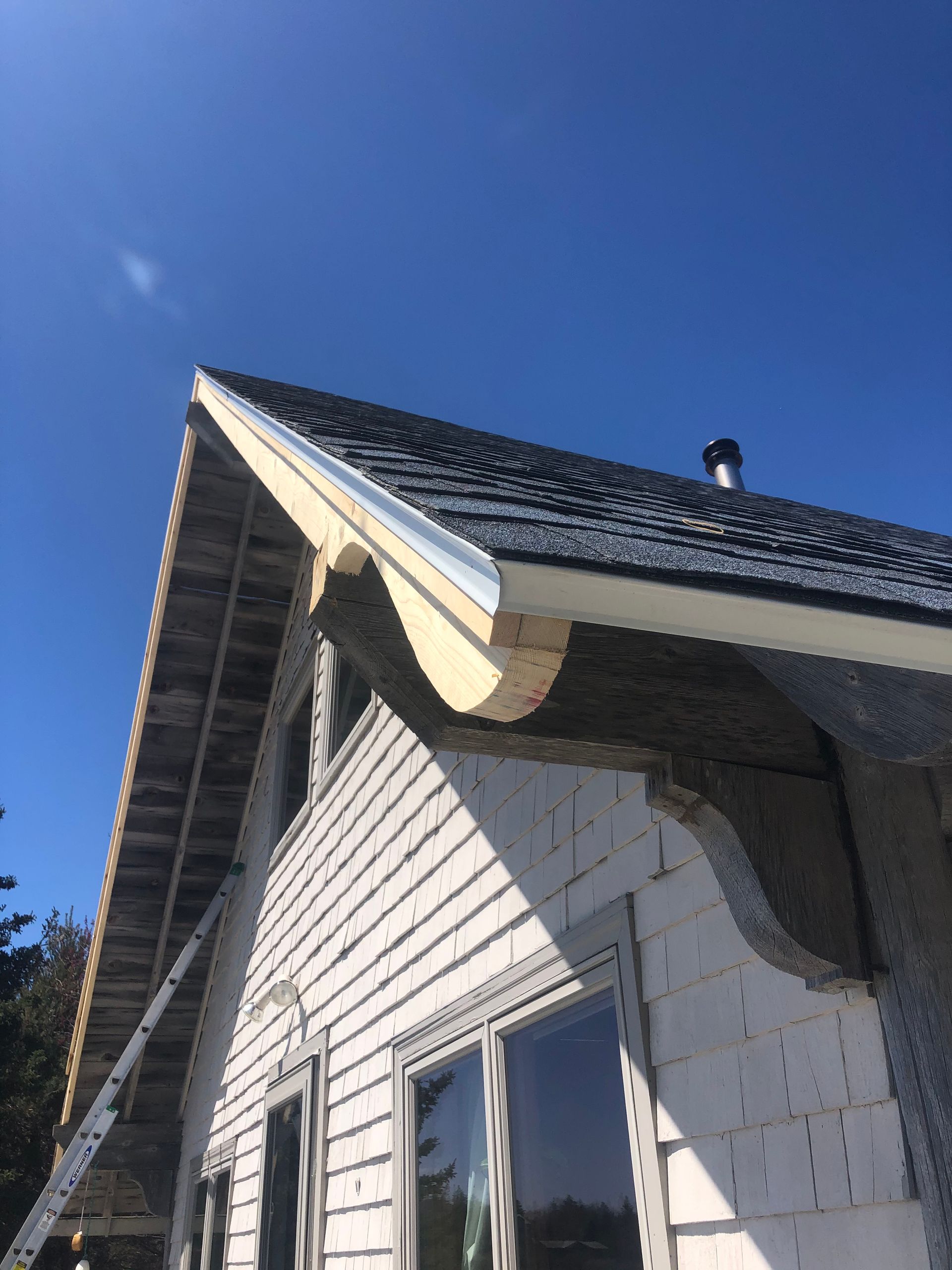 A white house with a roof that is being built