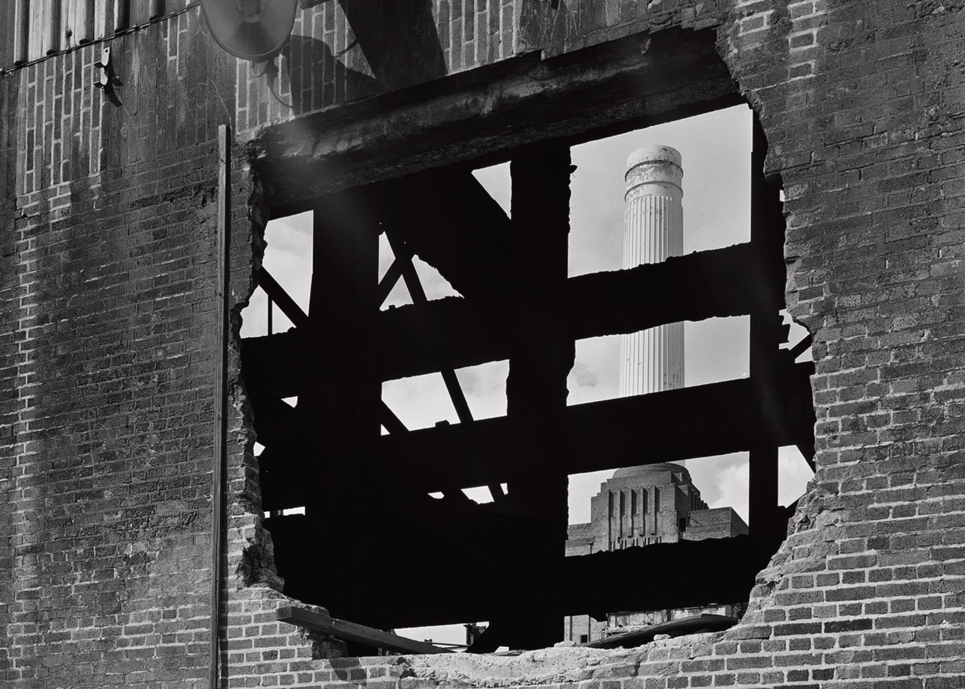 A black and white photo of a brick wall with a hole in it