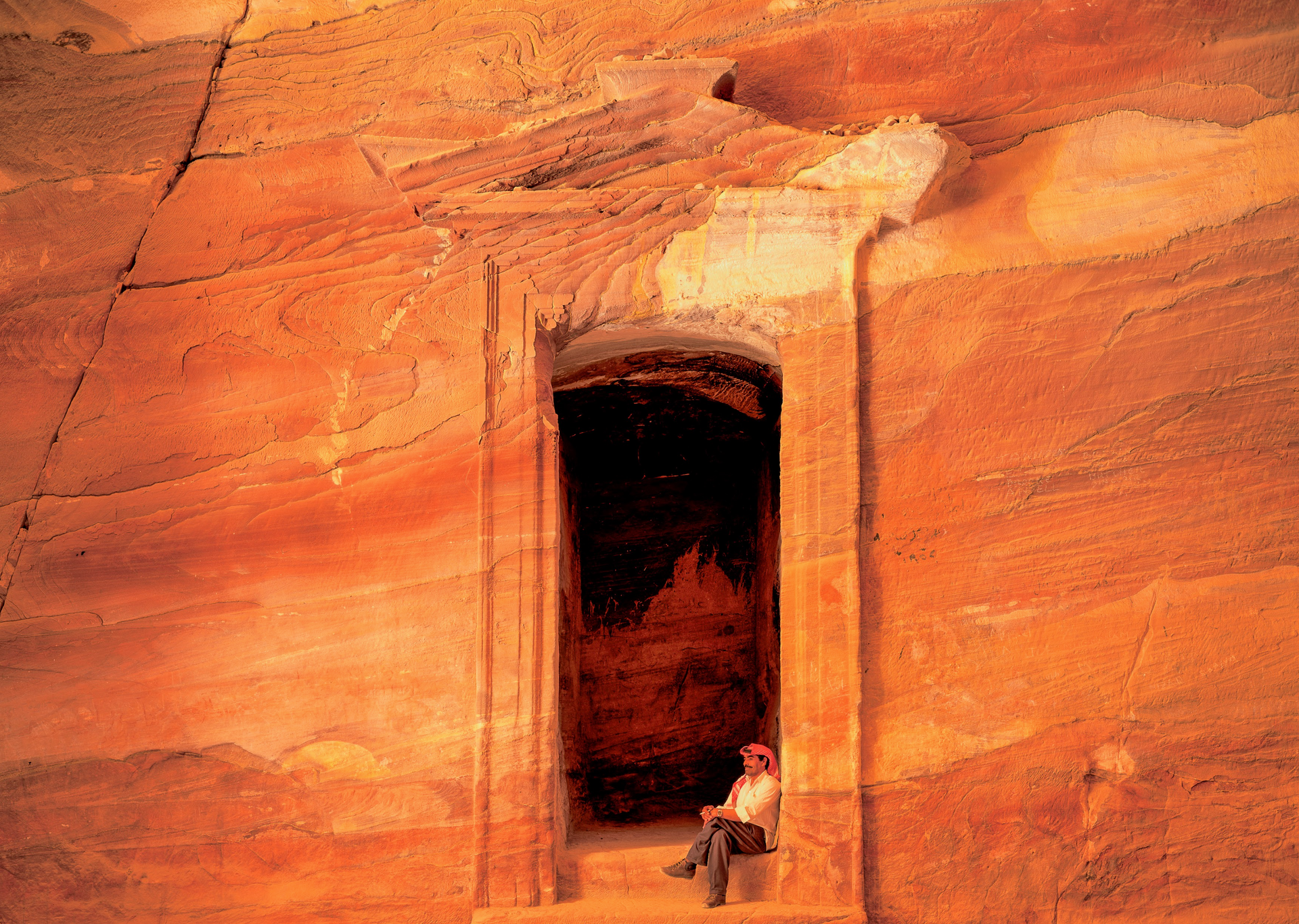A man is sitting in a window of a building.