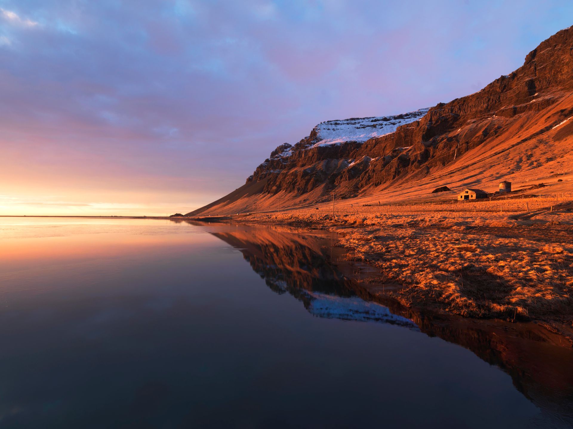 A sunset over a lake with mountains in the background
