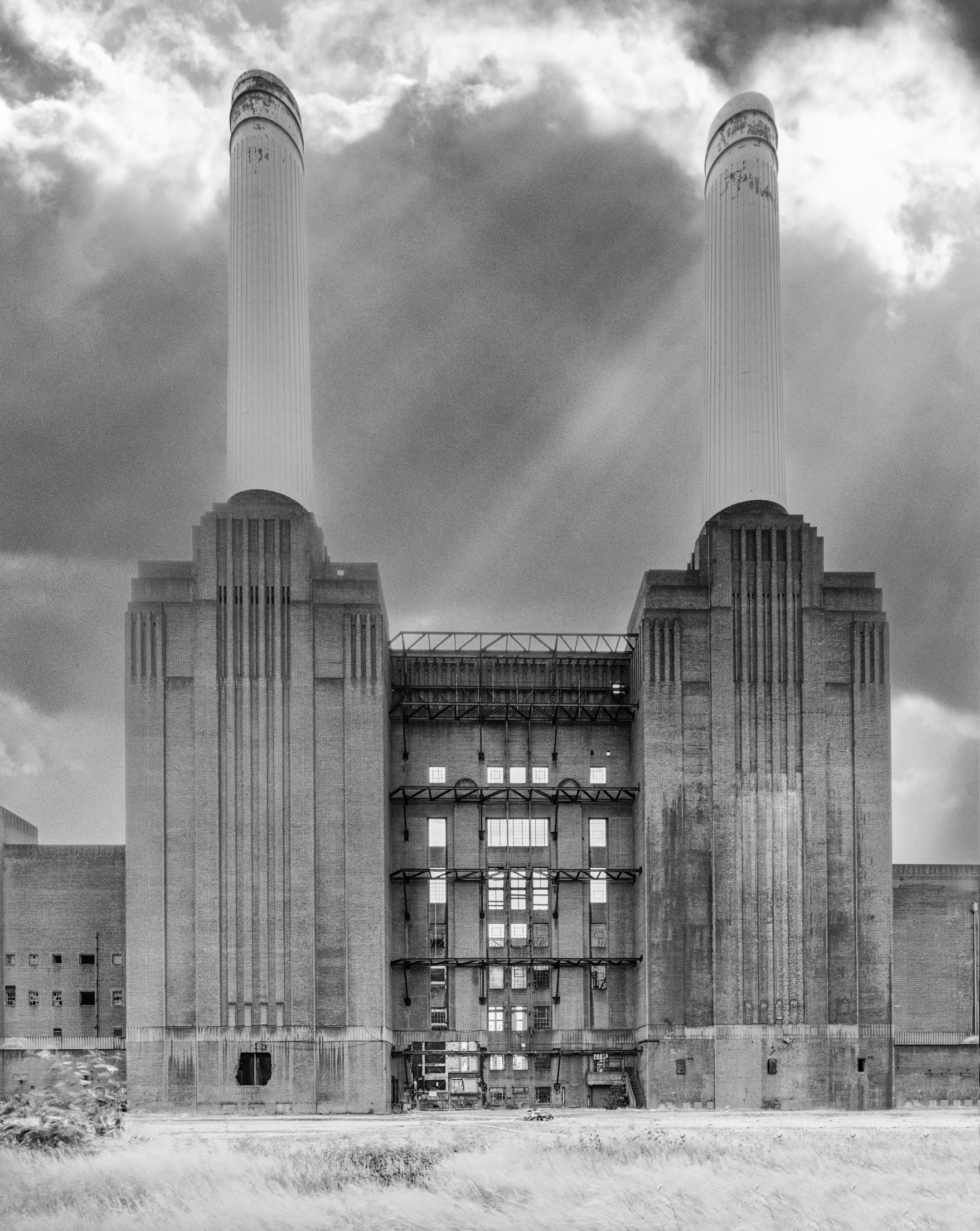 A black and white photo of a large building with two chimneys.