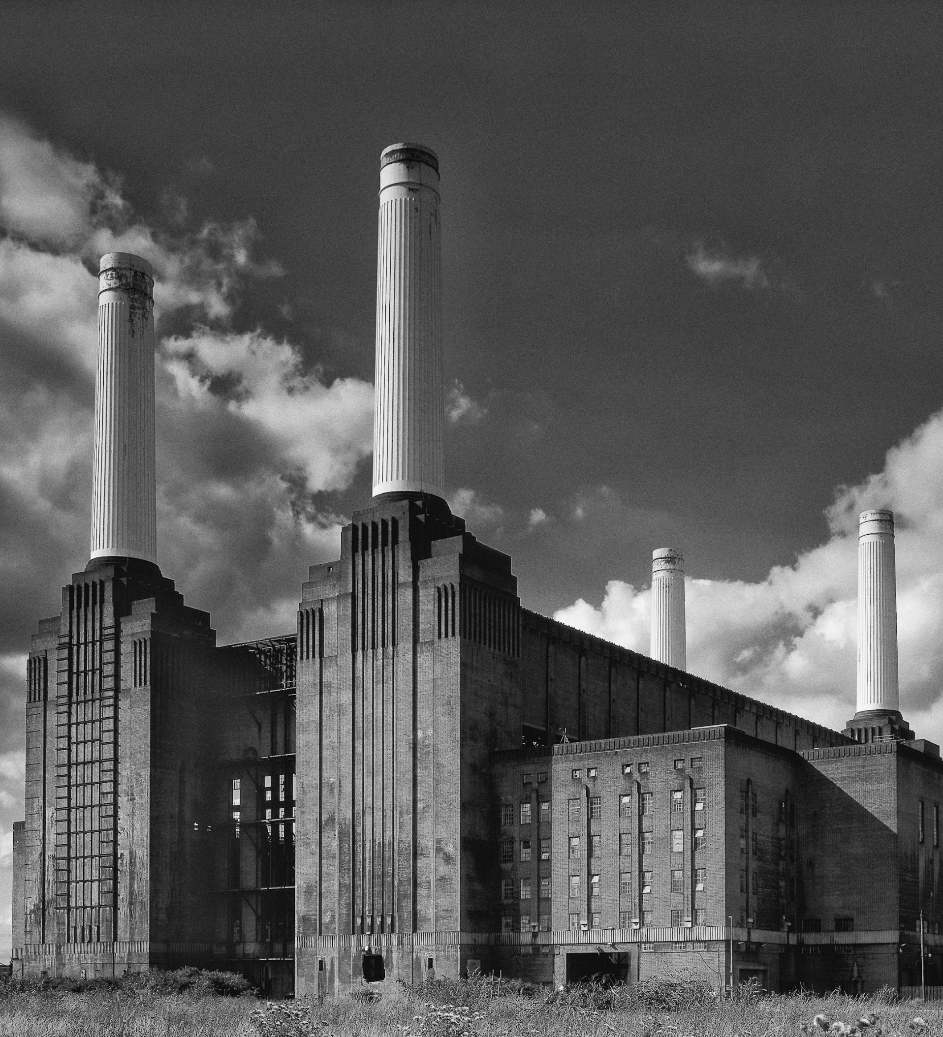 A black and white photo of a large building with chimneys