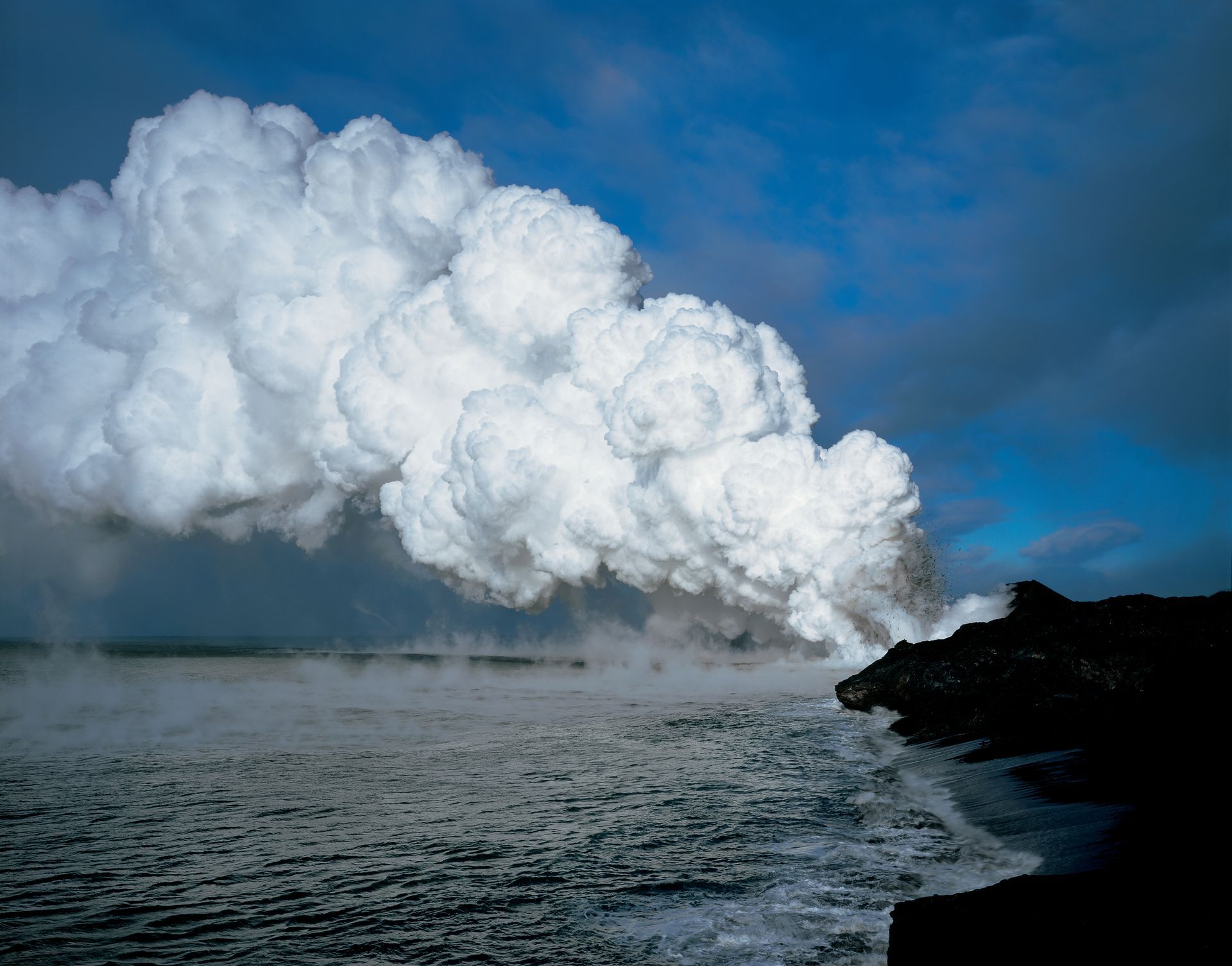 A large cloud of steam is coming out of a volcano