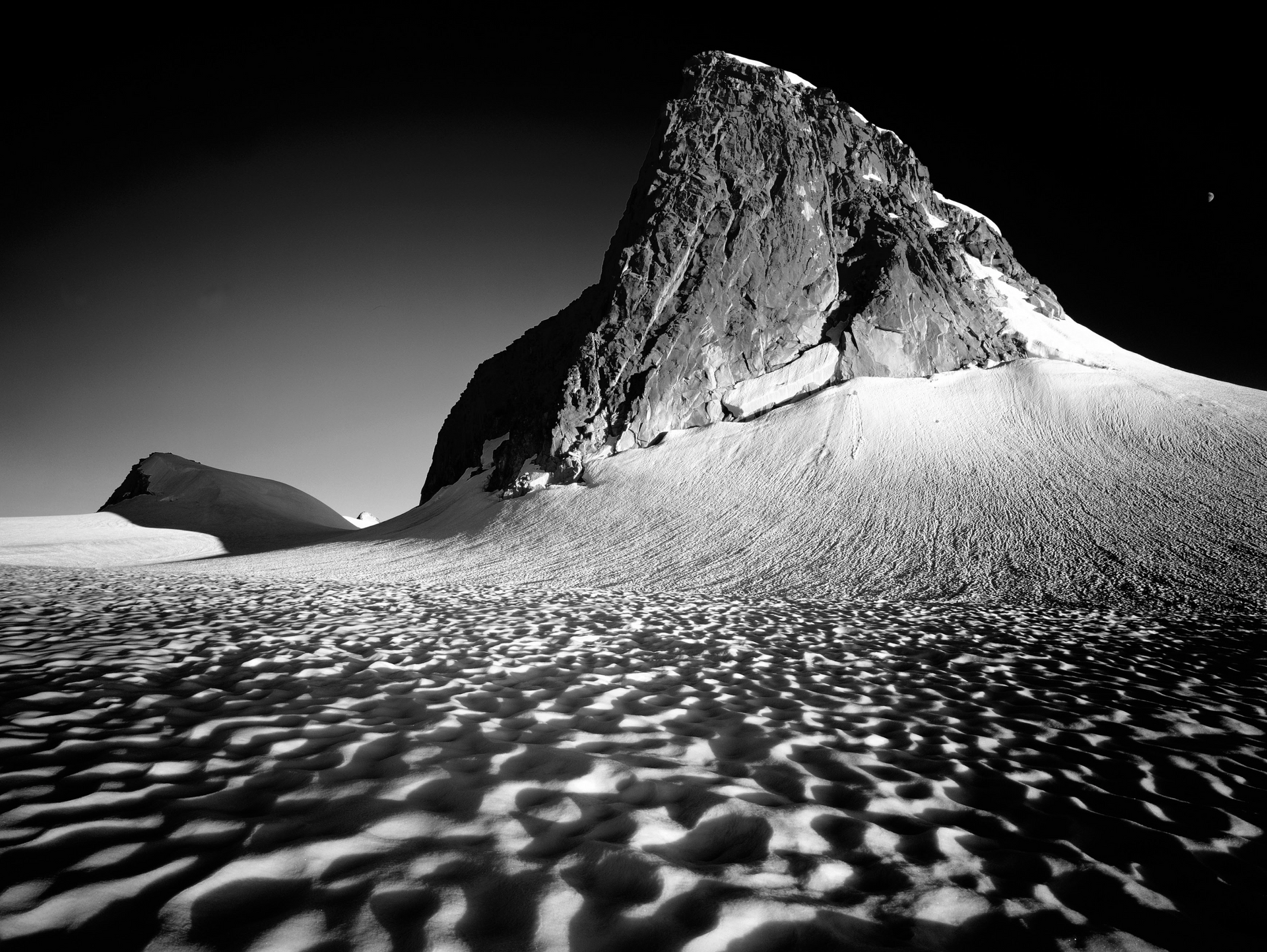A black and white photo of a mountain covered in snow