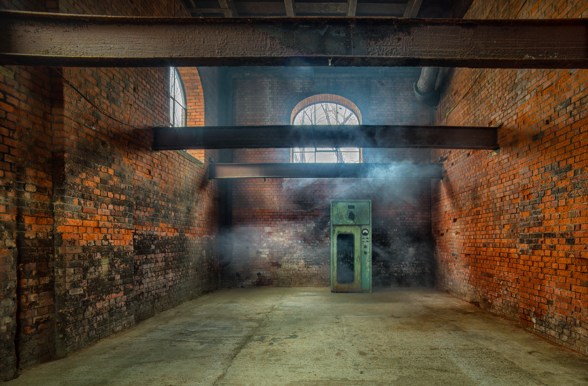 An empty room with brick walls and smoke coming out of the door.
