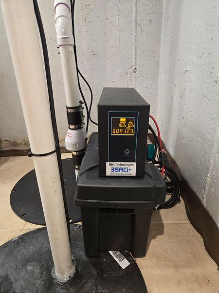 MDM Plumbing & Sewer LLC | A black ups is sitting on top of a black box in a basement.