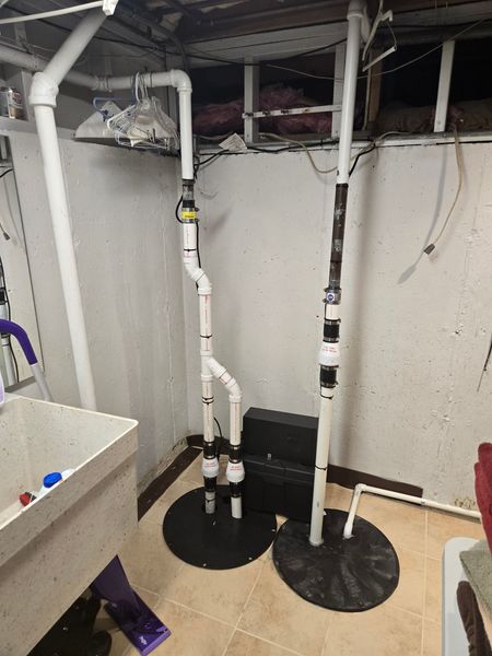 MDM Plumbing & Sewer LLC | A basement with a sink and a pump in it.