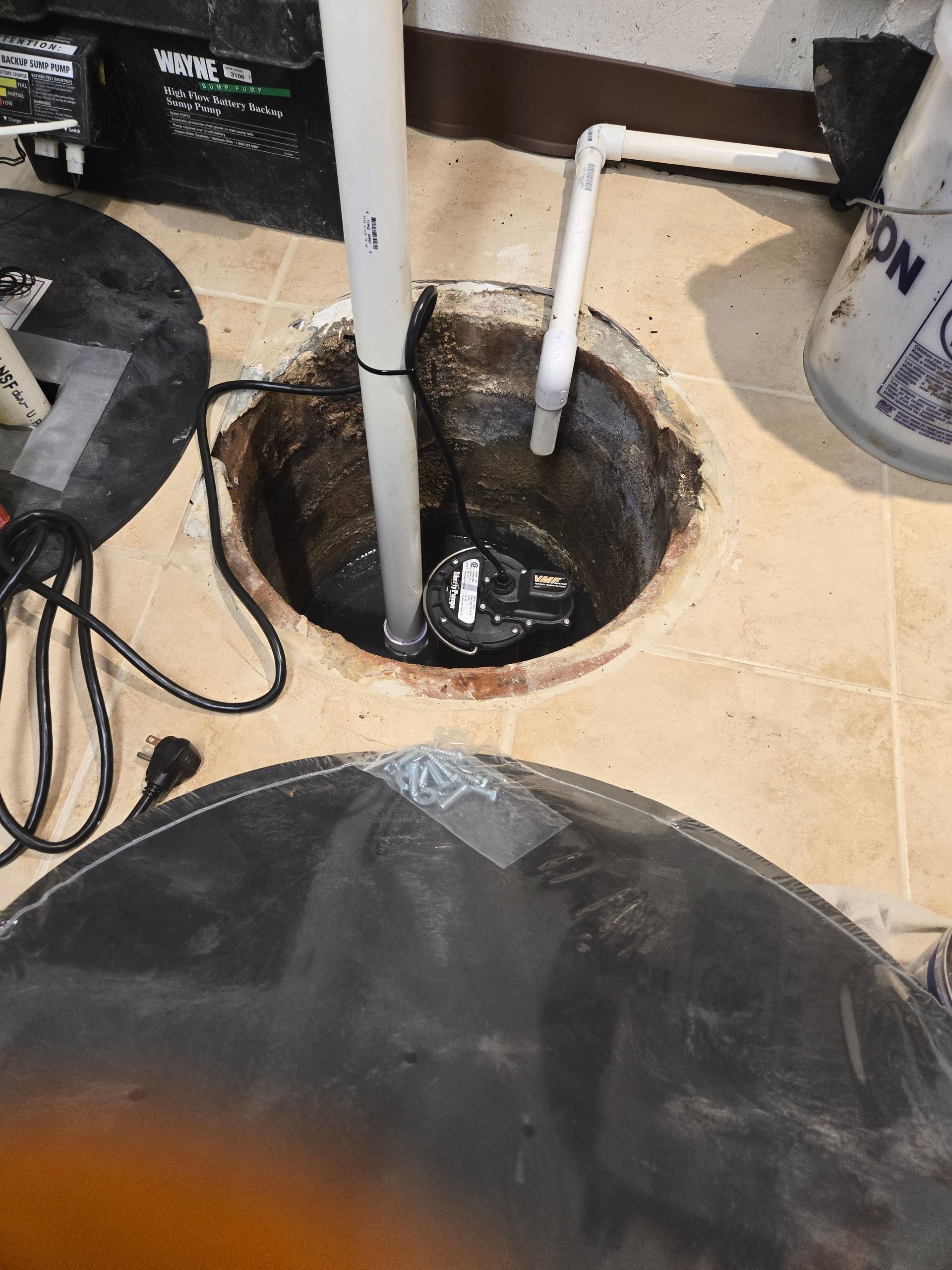 MDM Plumbing & Sewer LLC | A pump is sitting in a hole in the floor of a basement.