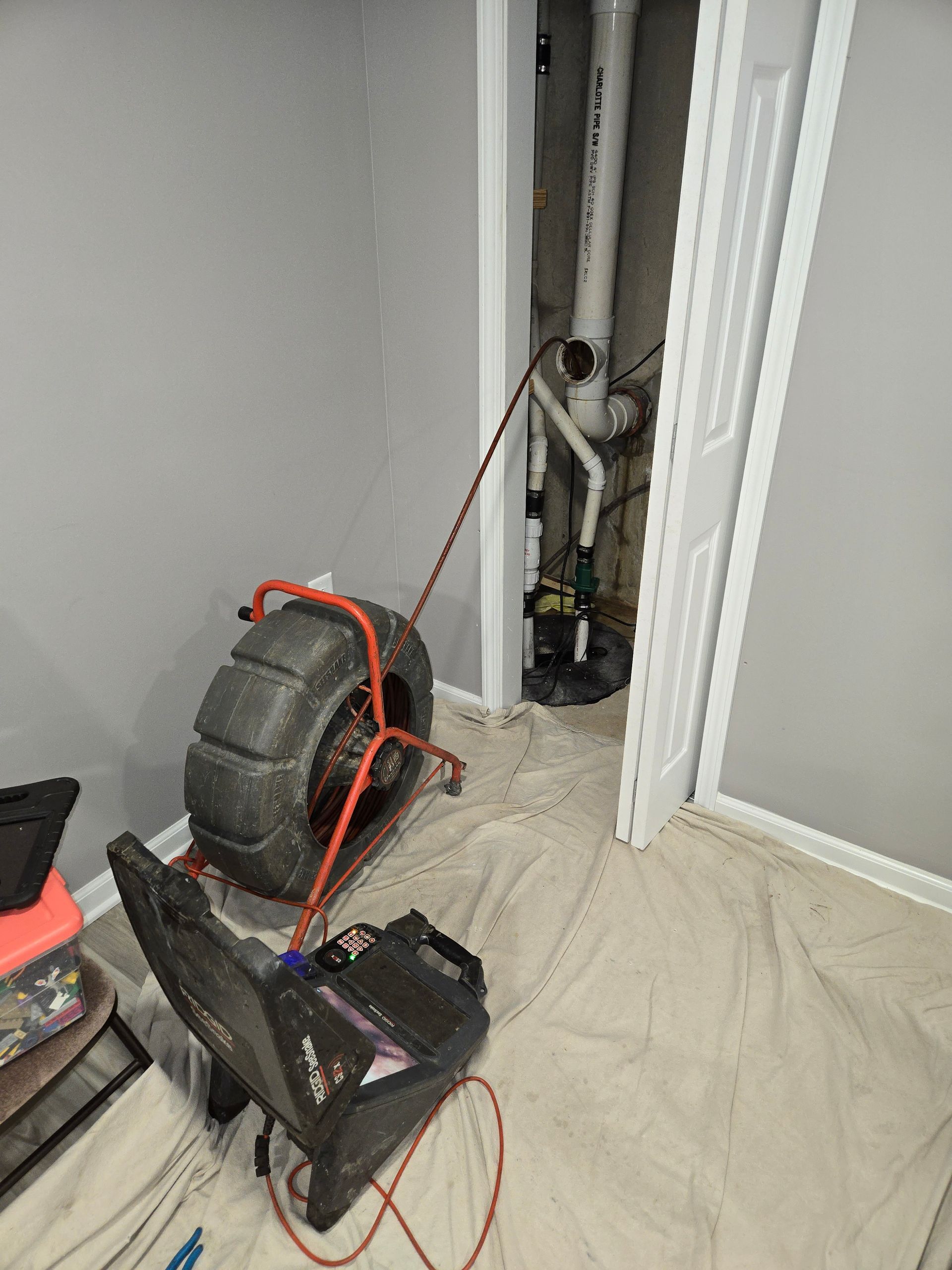 MDM Plumbing & Sewer LLC | A drain camera is sitting on the floor in a room next to a door.