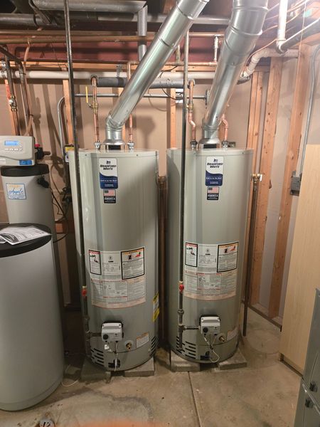 MDM Plumbing & Sewer LLC | Two water heaters are sitting next to each other in a basement.