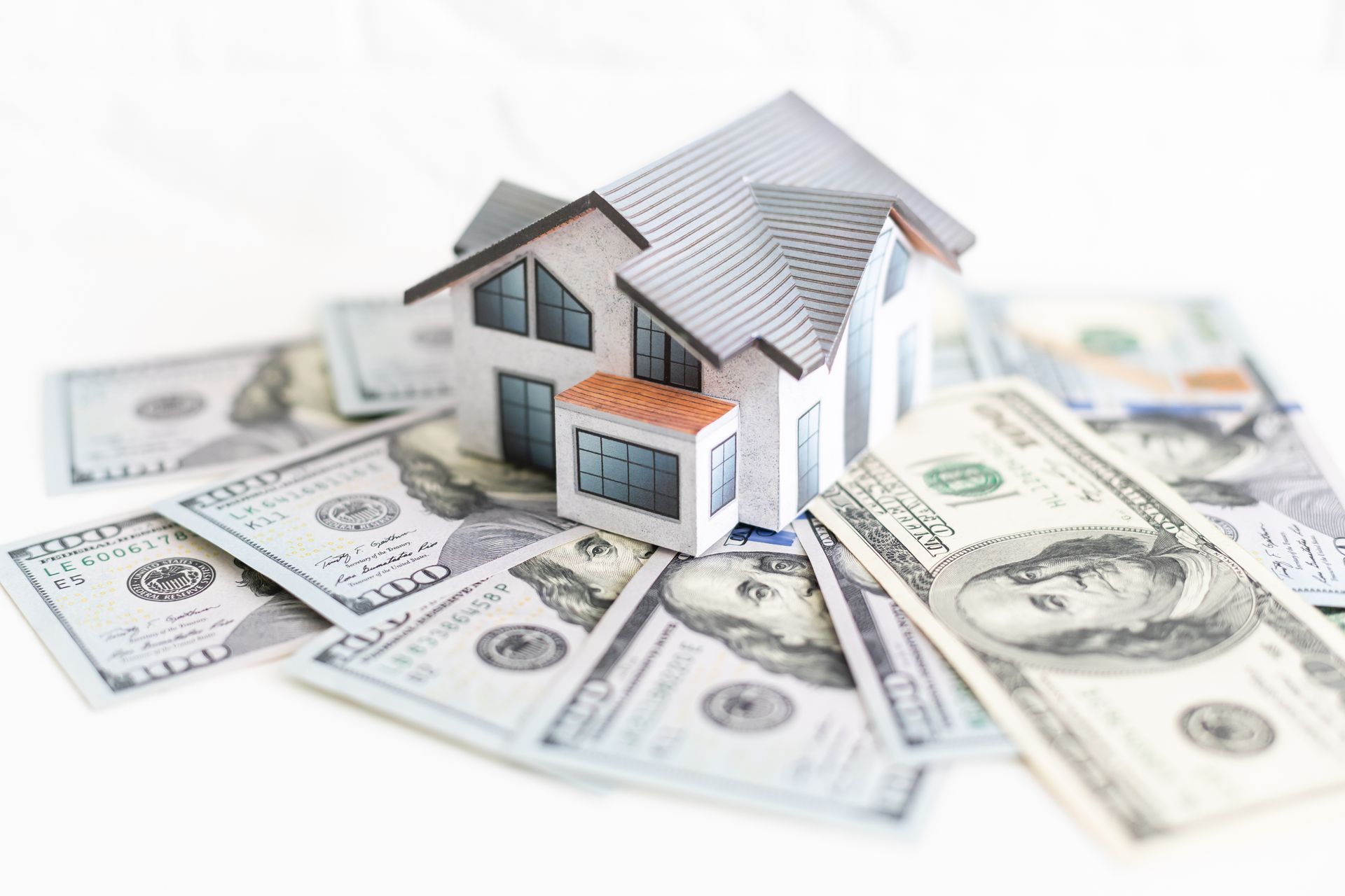 Model house on $100 bills illustrating home renovation loans, budgeting, and financing options.