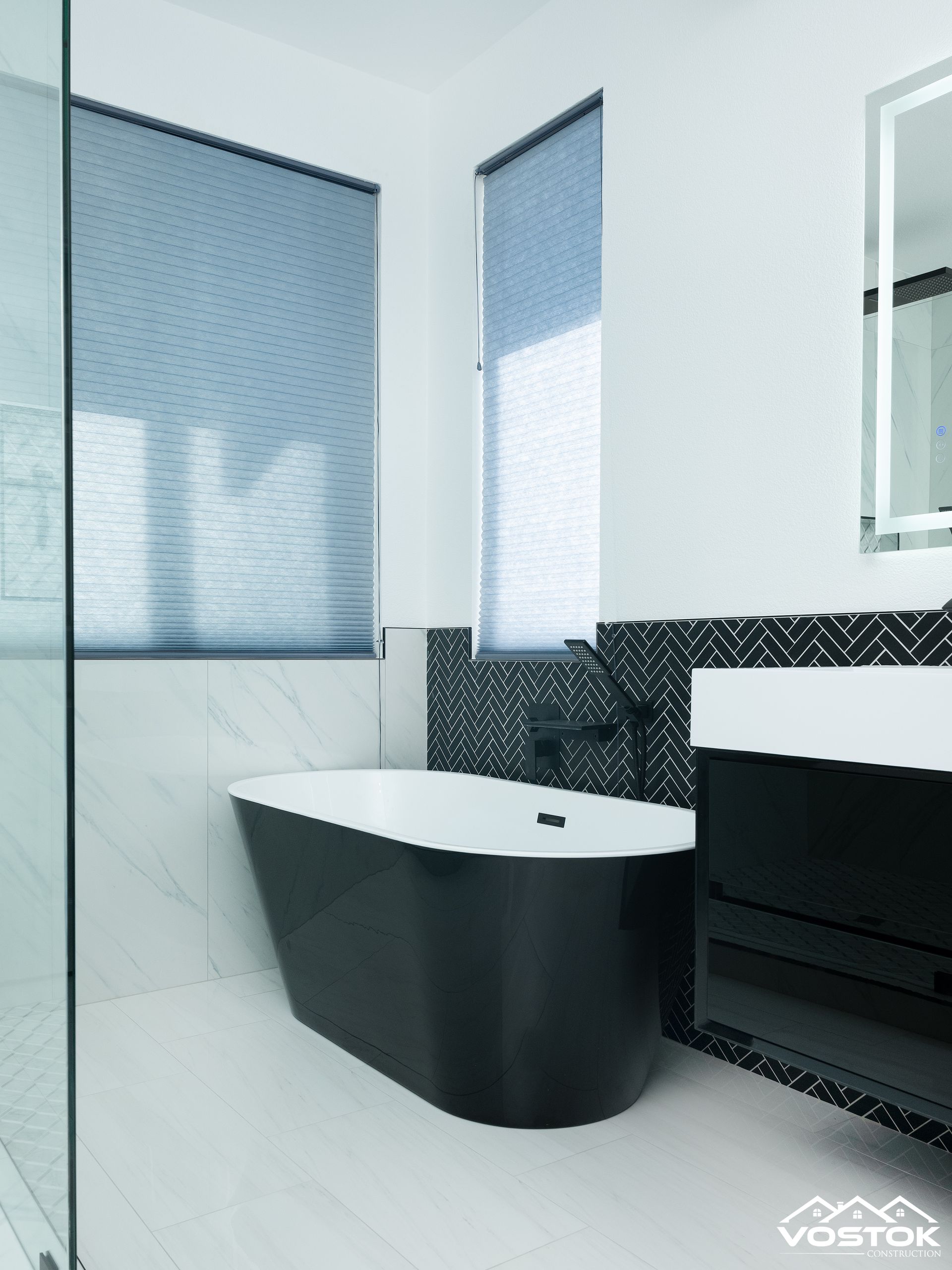 A bathroom with a black tub and a white sink