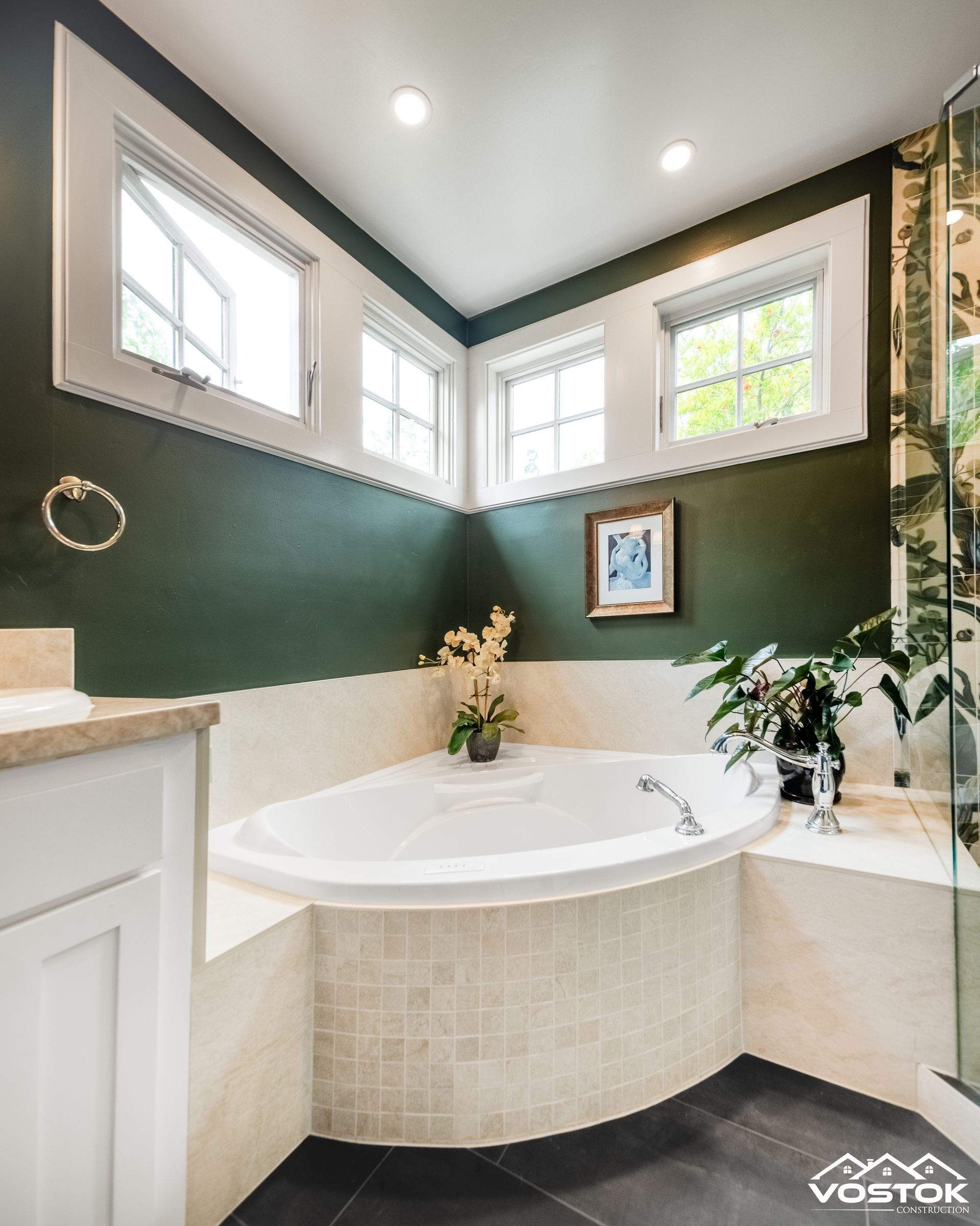 A bathroom with a corner tub and green walls