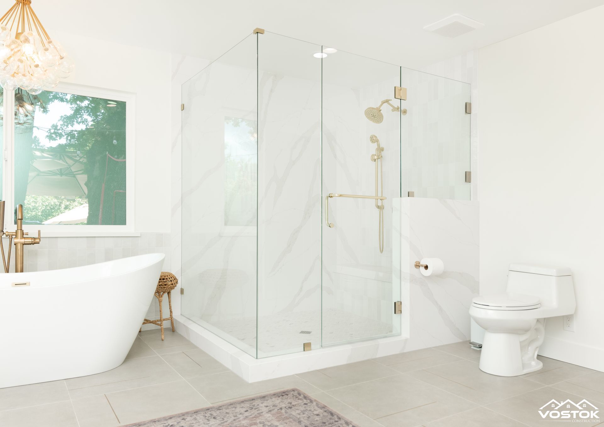 A bathroom with a tub , toilet , shower and window.