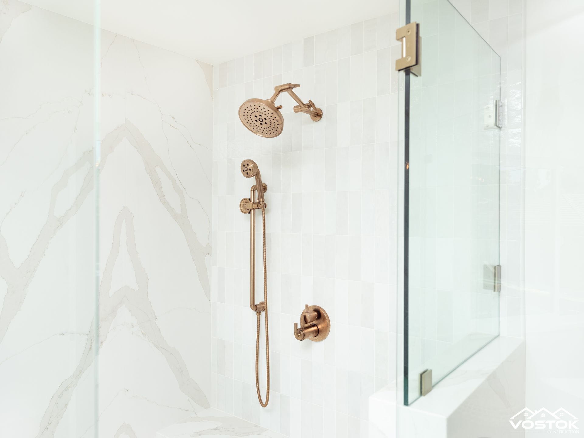A bathroom with a shower head and a glass door.