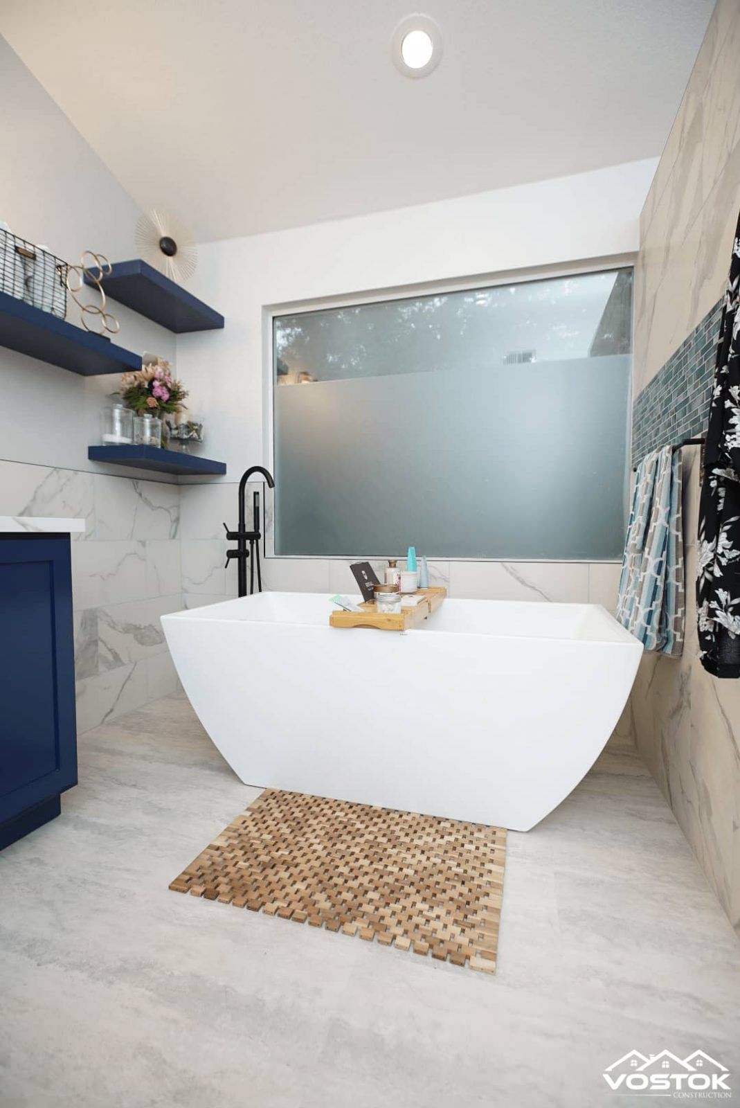 A bathroom with a bathtub and a window.