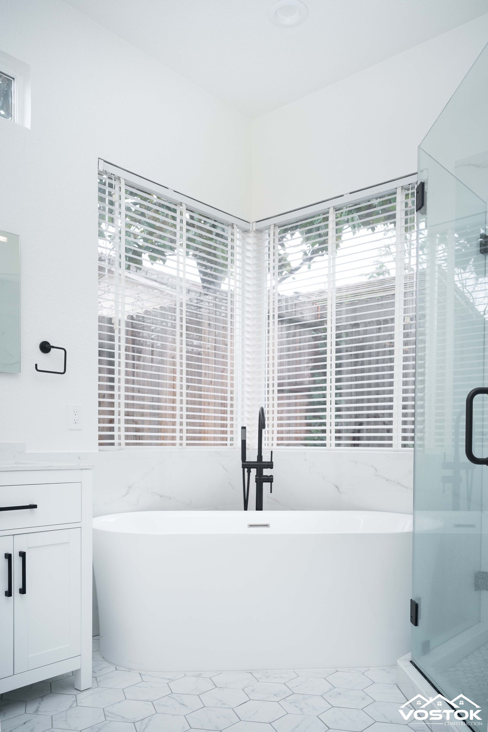 A bathroom with a bathtub , sink , and shower.