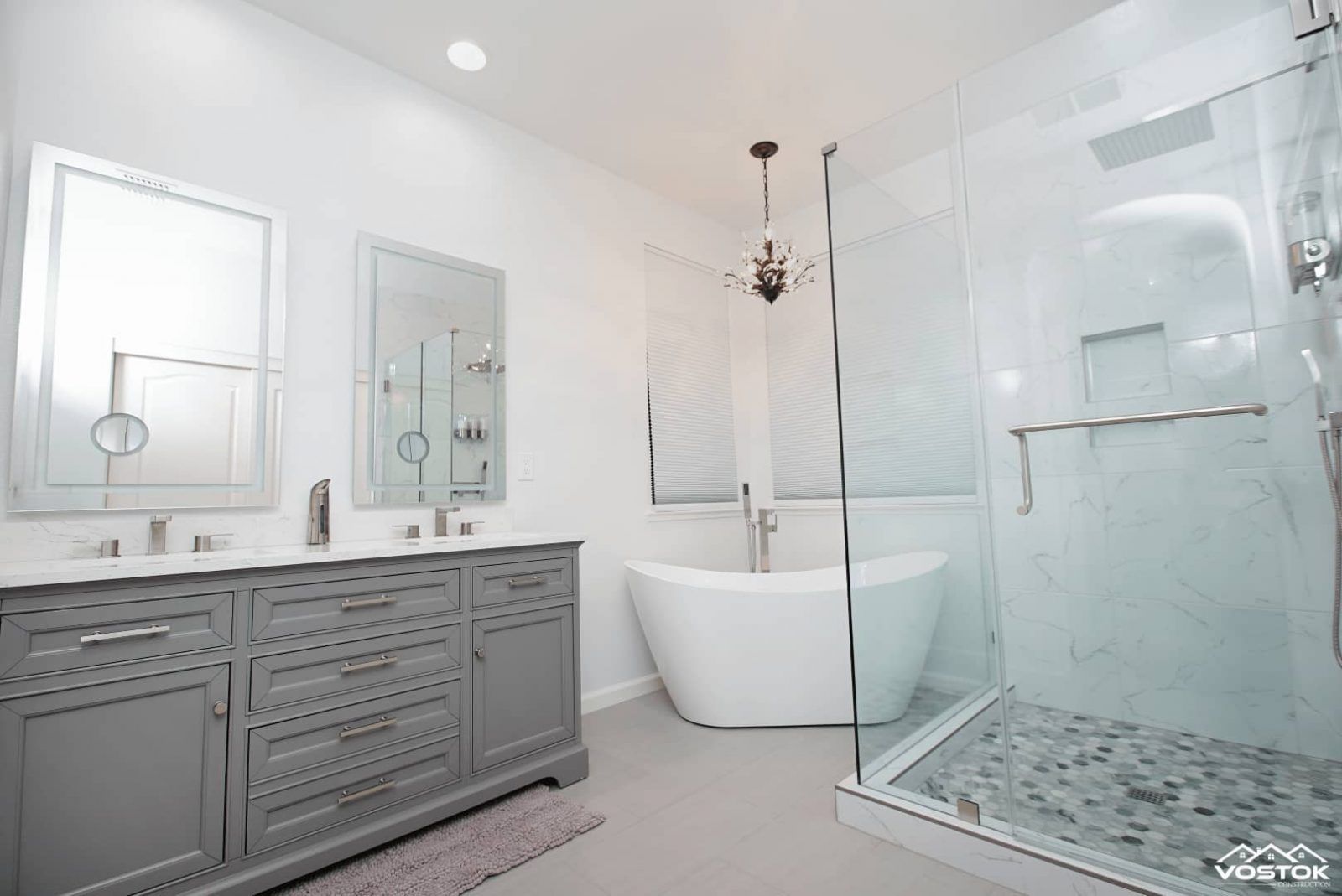 A bathroom with two sinks , a tub , and a walk in shower.