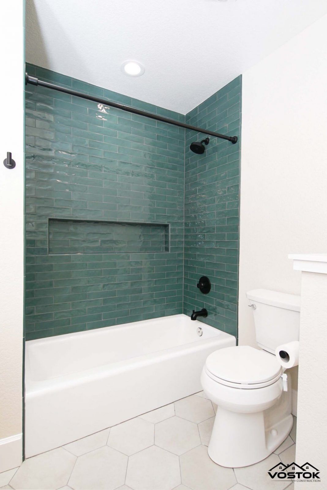 A bathroom with a tub , toilet , and shower.