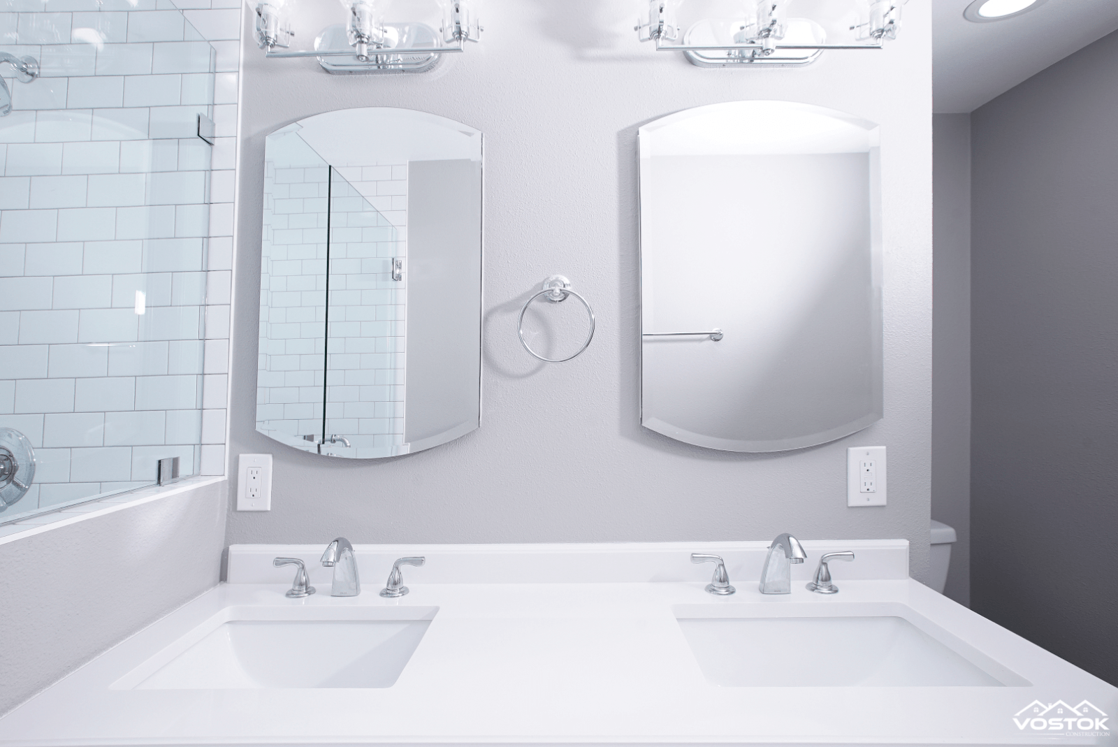 A bathroom with two sinks and two mirrors.