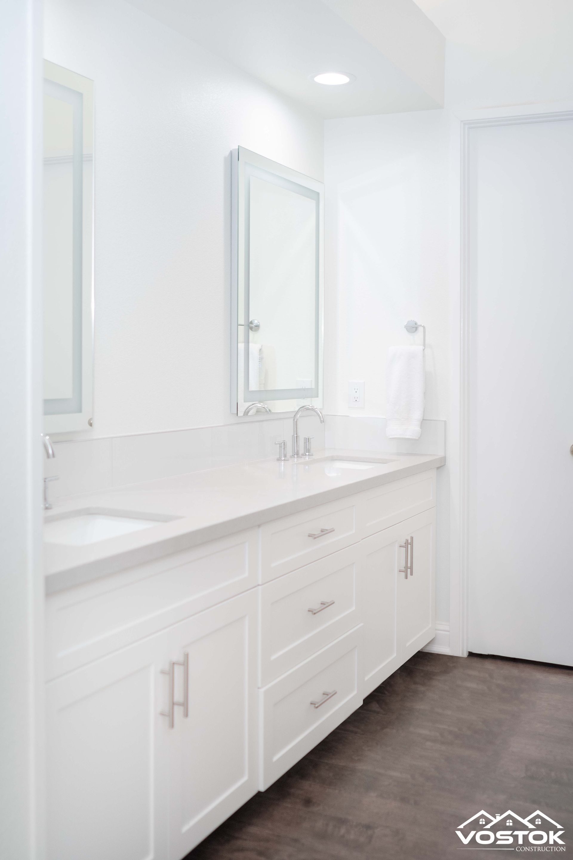 A bathroom with two sinks and a mirror.