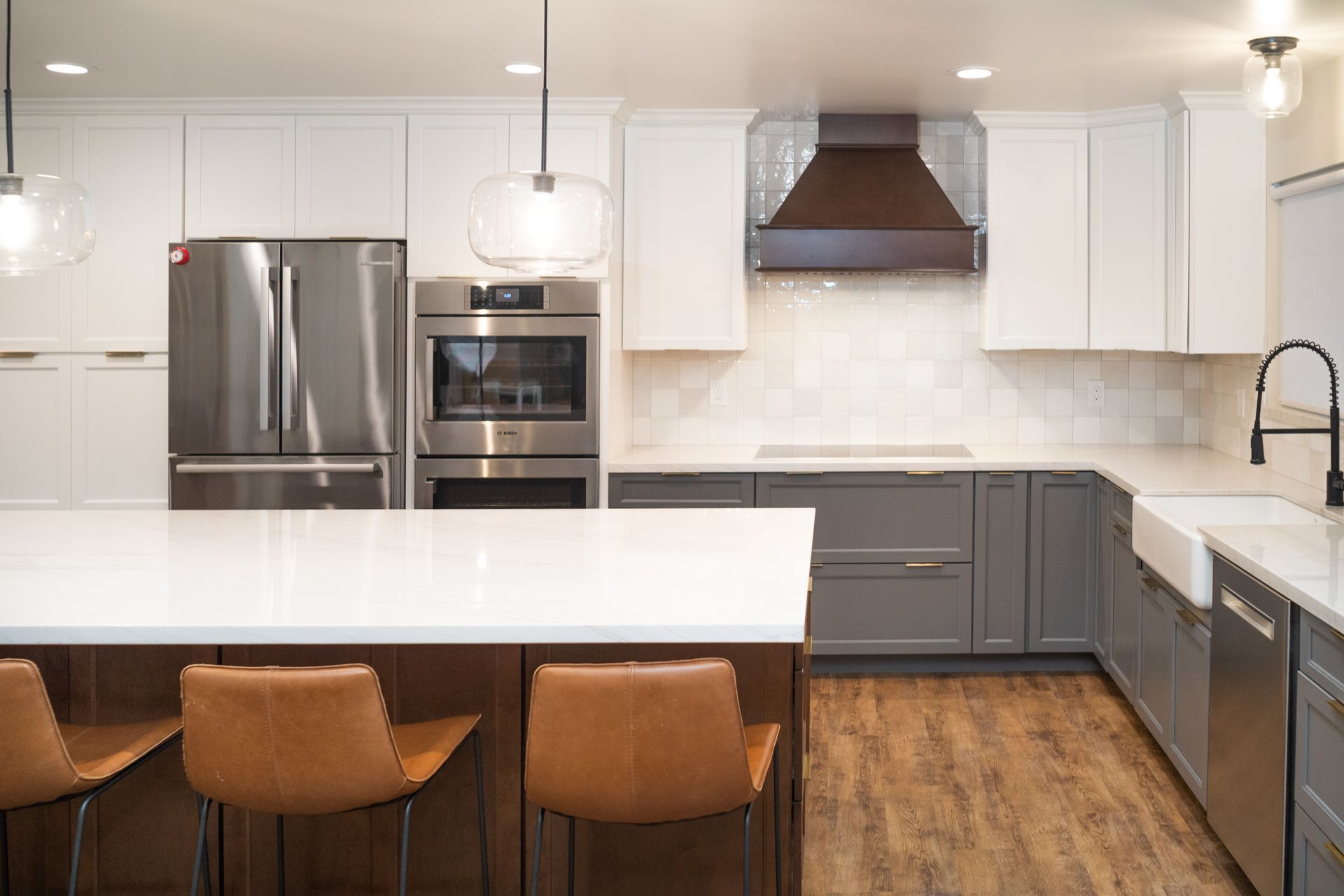 A kitchen with white cabinets , stainless steel appliances , and a large island.