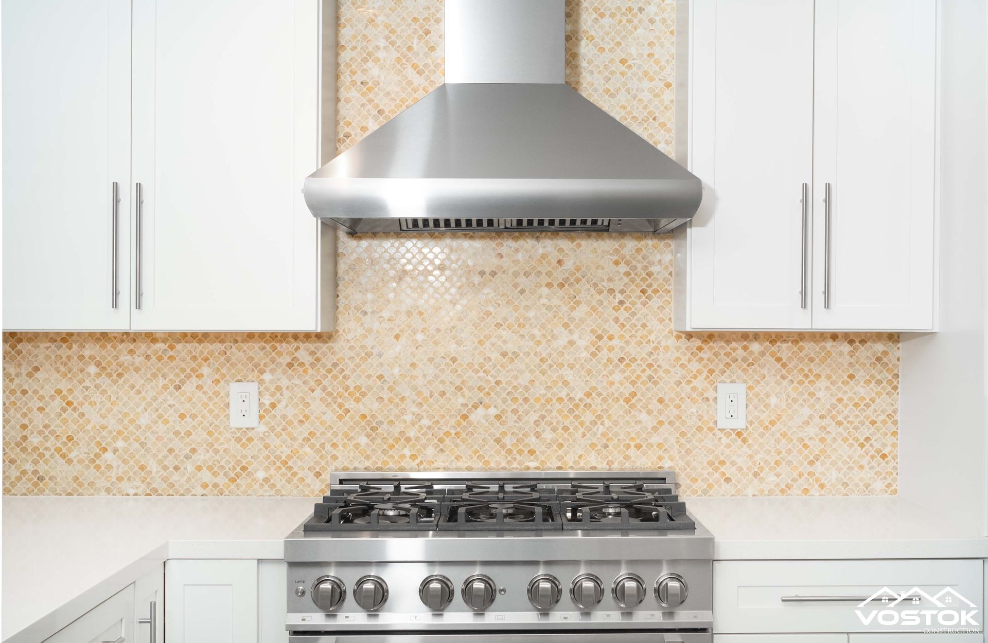A kitchen with a stove and a hood above it